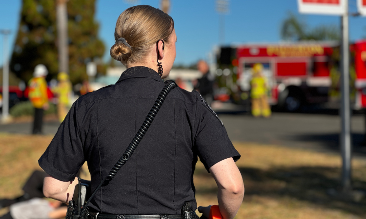 An officer in uniform and a red fire engine in the background