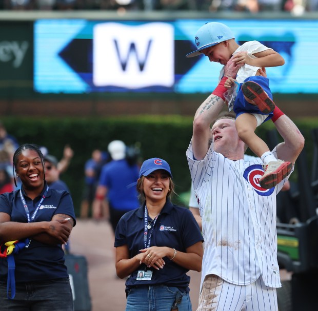 Cubs center fielder Pete Crow-Armstrong lifts a child as he celebrates a 10-inning victory over the Giants on Saturday, June 6, 2026, at Wrigley Field. (Chris Sweda/Chicago Tribune)