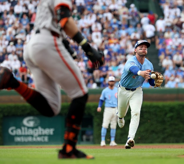 Chicago Cubs second baseman Nico Hoerner (2) tosses the ball to first base on a ground out by San Francisco Giants designated hitter Bryce Eldridge (left) in the second inning of a game at Wrigley Field in Chicago on June 5, 2026. (Chris Sweda/Chicago Tribune)
