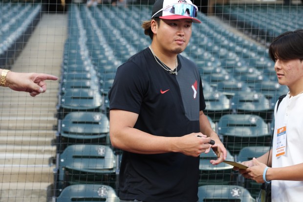 Injured White Sox first baseman Munetaka Murakami signs autographs before a game against the Dodgers at Rate Field on June 12, 2026, in Chicago. (John J. Kim/Chicago Tribune)