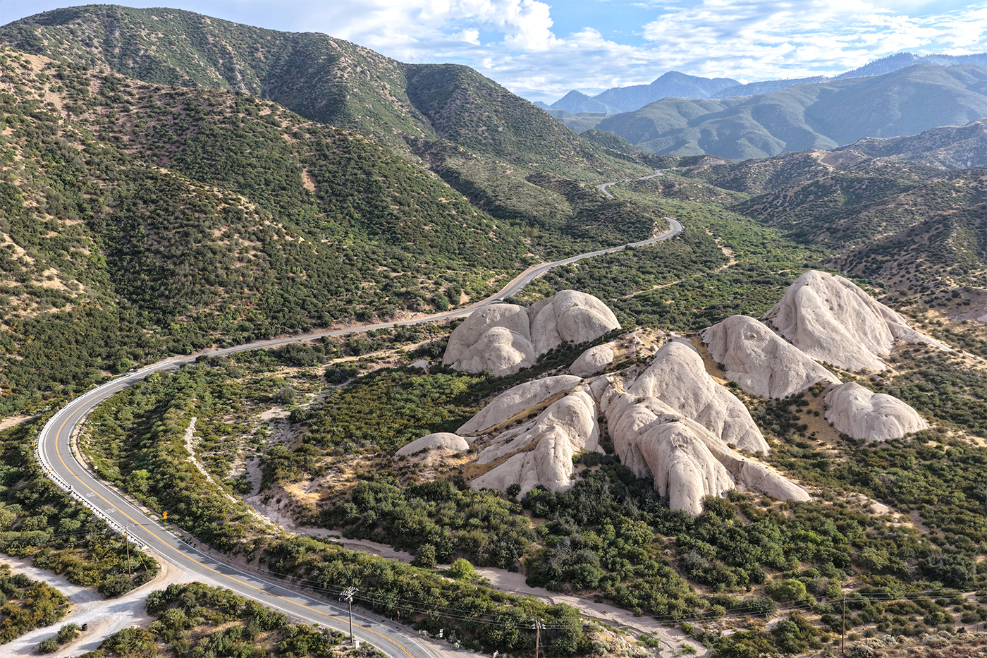 Winding road cutting through rocky, scrub-covered hills in Northern California near the San Andreas fault zone.