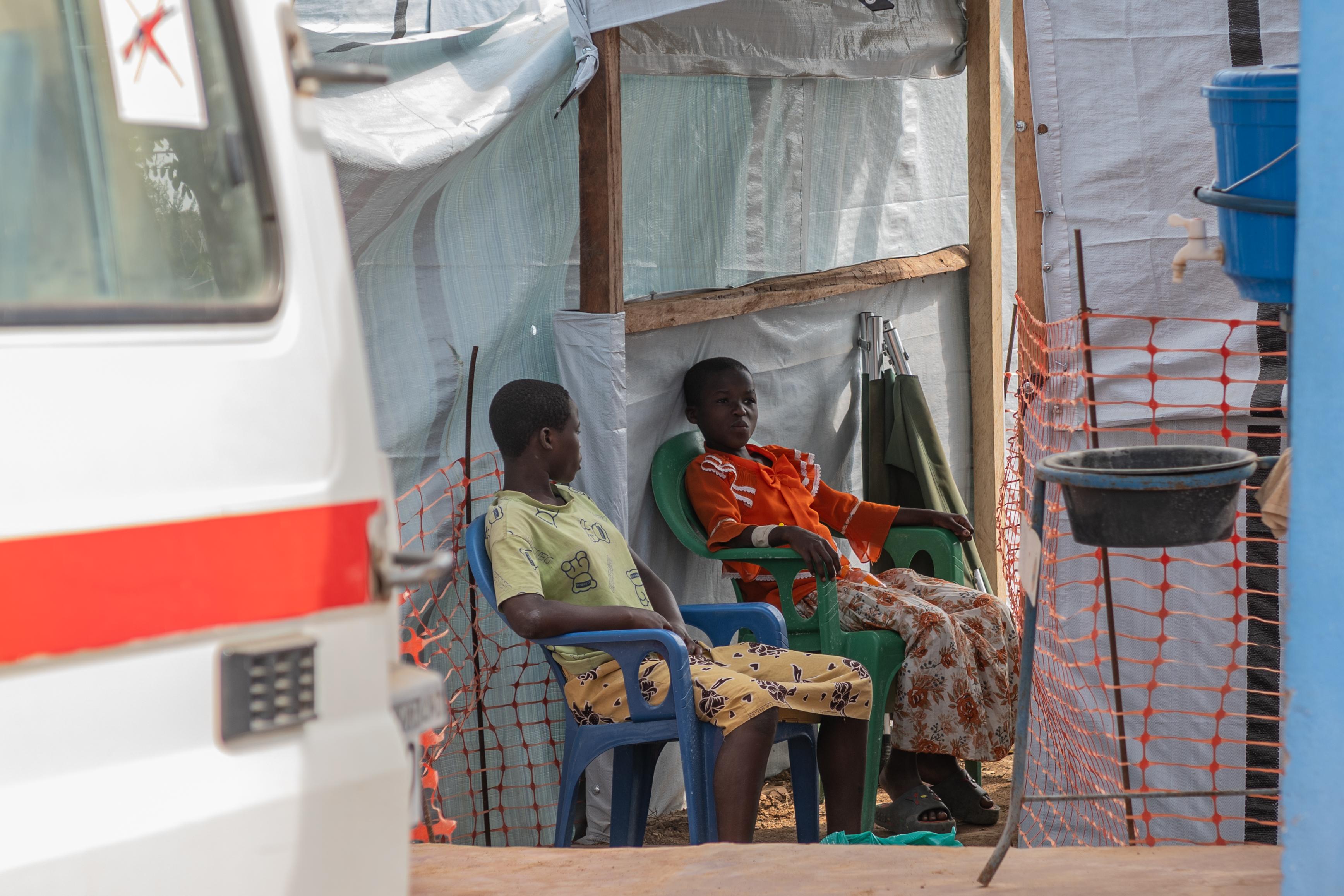 Two girls sit at the isolation center in Bunia, Congo,...
