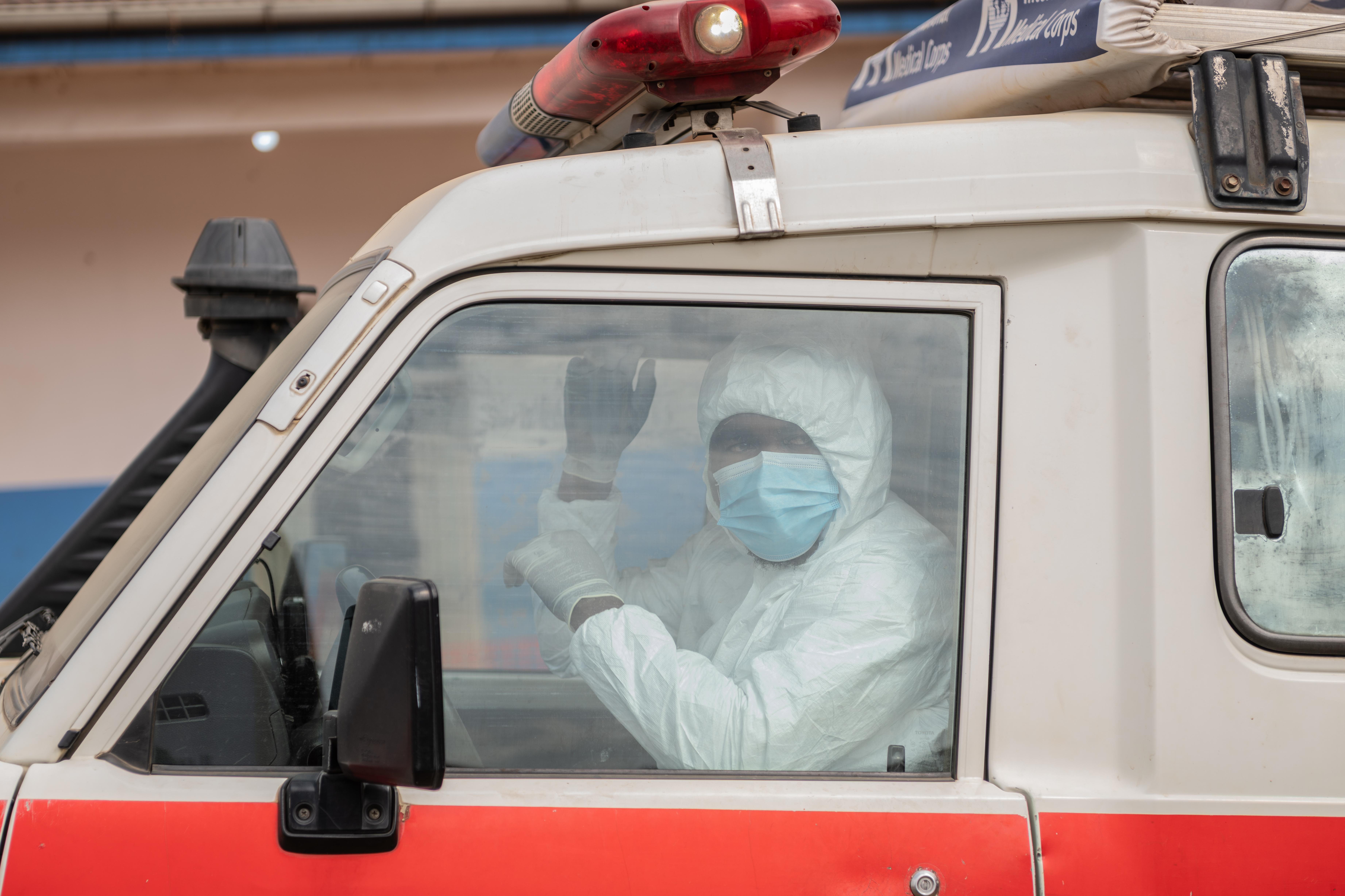 A paramedic transports a suspected Ebola case to a treatment...