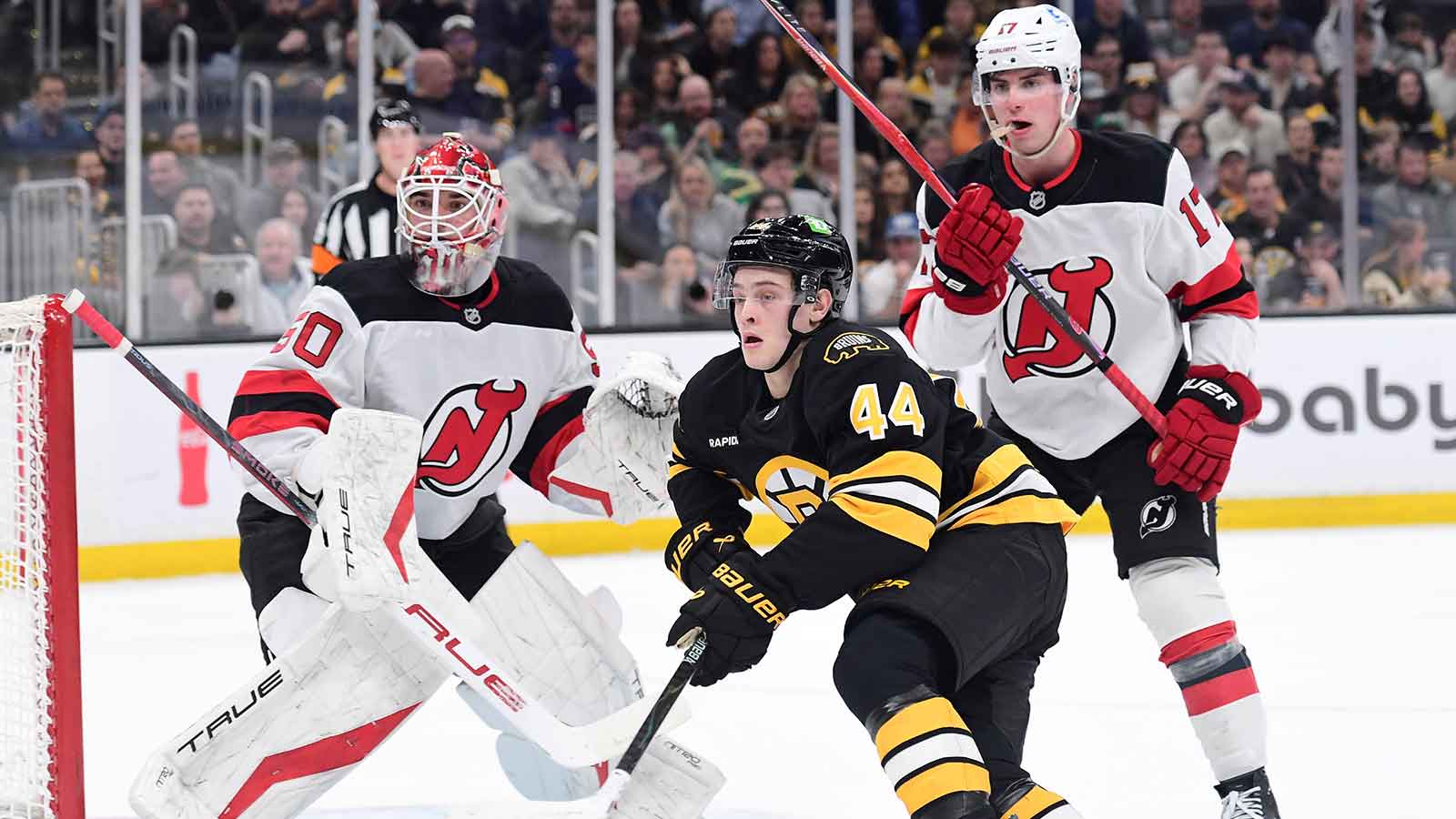 New Jersey Devils goalie Nico Daws (50) looks on as defenseman Simon Nemec (17) and Boston Bruins forward James hagen (44) go after the puck during the first period at TD Garden.