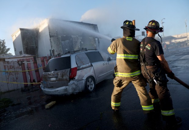 Oakland firefighters put out hot spots at a two-alarm fire on International Boulevard at 90th Avenue in Oakland, Calif., on Saturday, June 13, 2026. (Jane Tyska/Bay Area News Group)