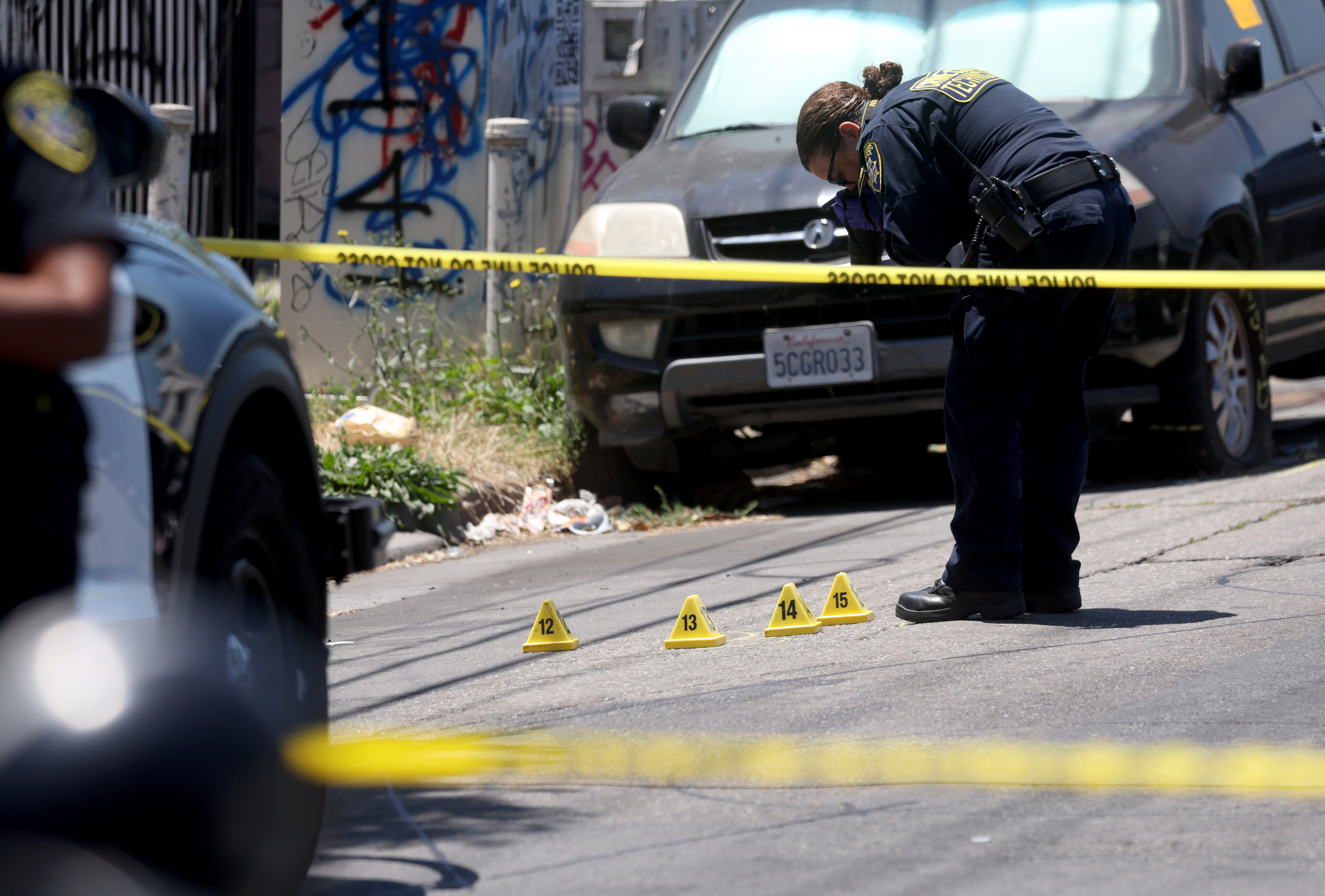 Oakland police and crime scene technicians investigate a fatal shooting...