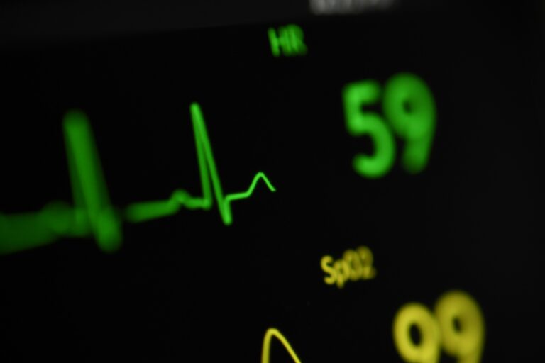A close-up photo showing an EKG line, with a spike up and wavy lines after, adjacent to numbers showing heart rate.