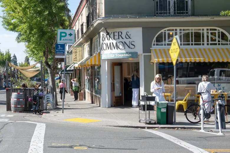 People mill around the storefront of Baker and Commons