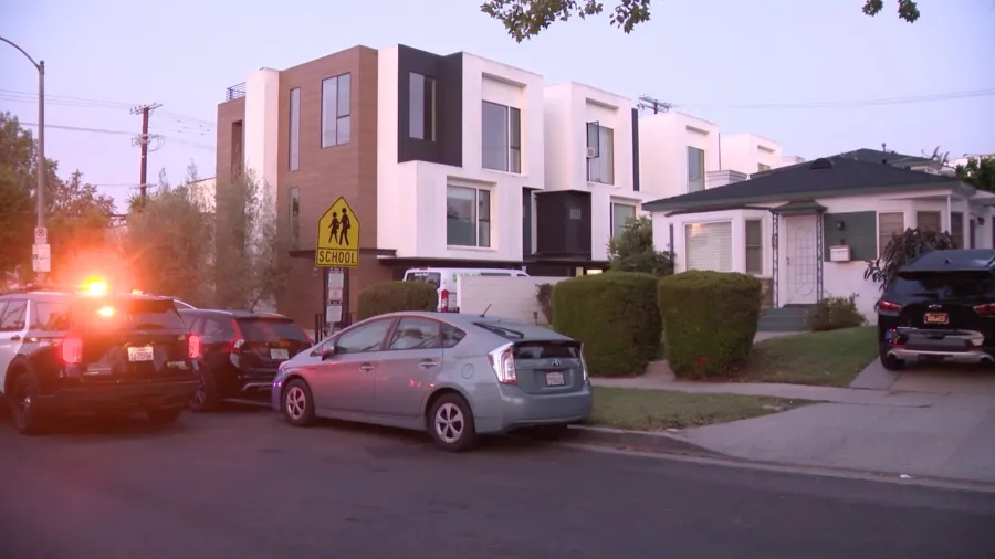 LAPD officers and patrol vehicles outside a residential property on North Detroit Street in Los Angeles following a reported armed home invasion robbery in June 2026.