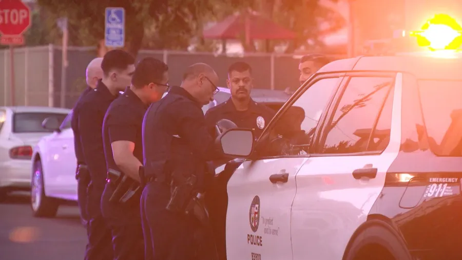 LAPD officers and patrol vehicles outside a residential property on North Detroit Street in Los Angeles following a reported armed home invasion robbery in June 2026.