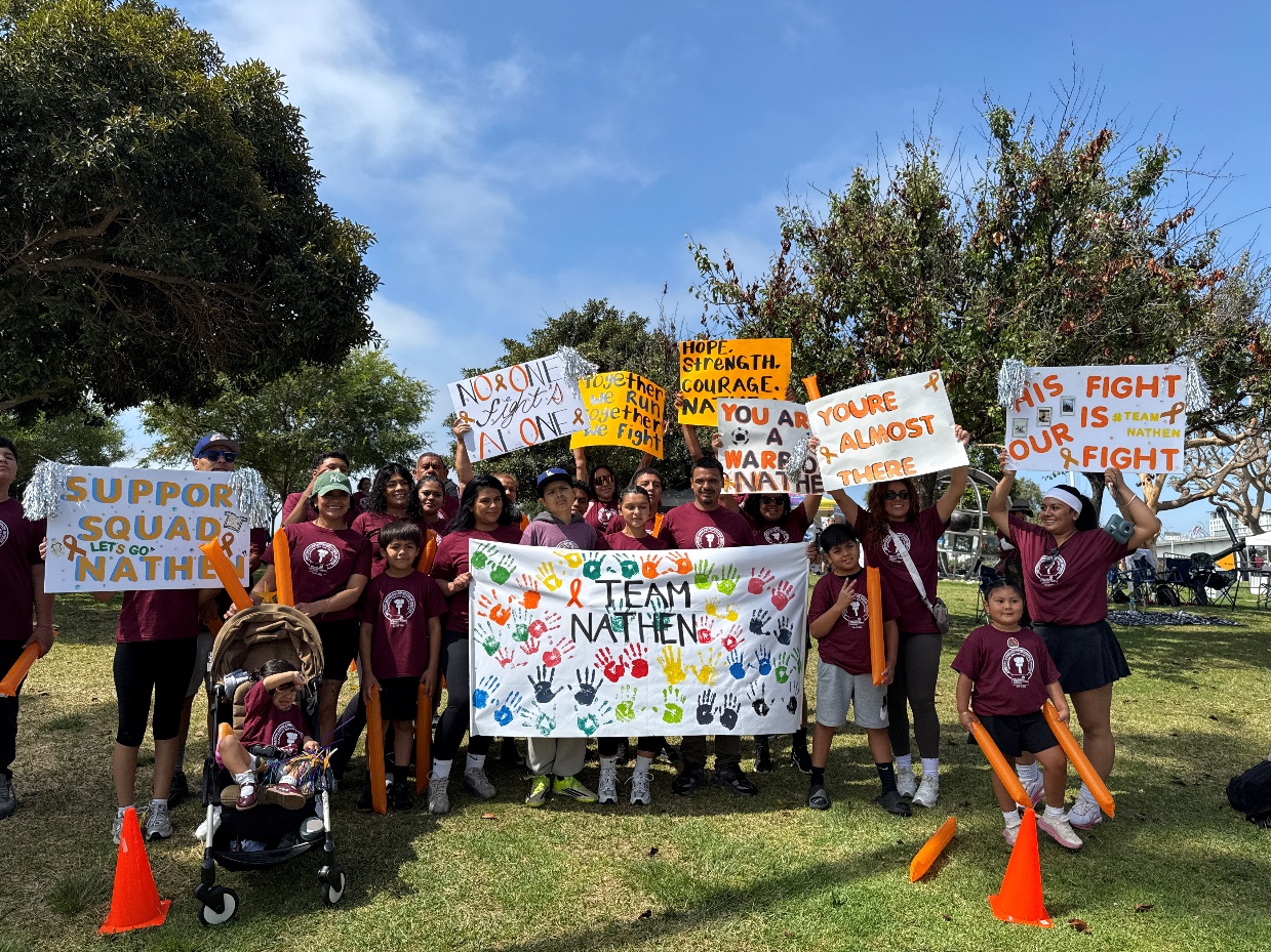 Surrounded by colorful banners, signs and orange clappers, Nathenâs family...