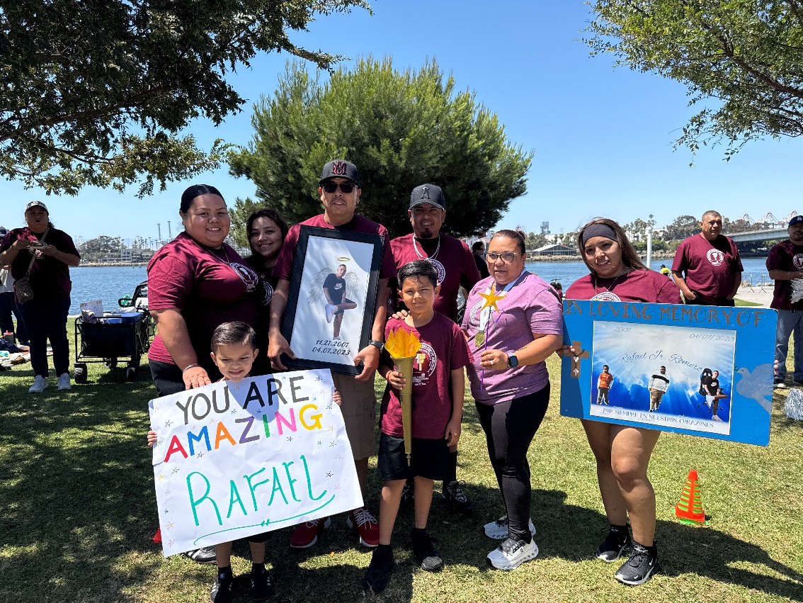 The Romero family carries a photo with angel wings in...