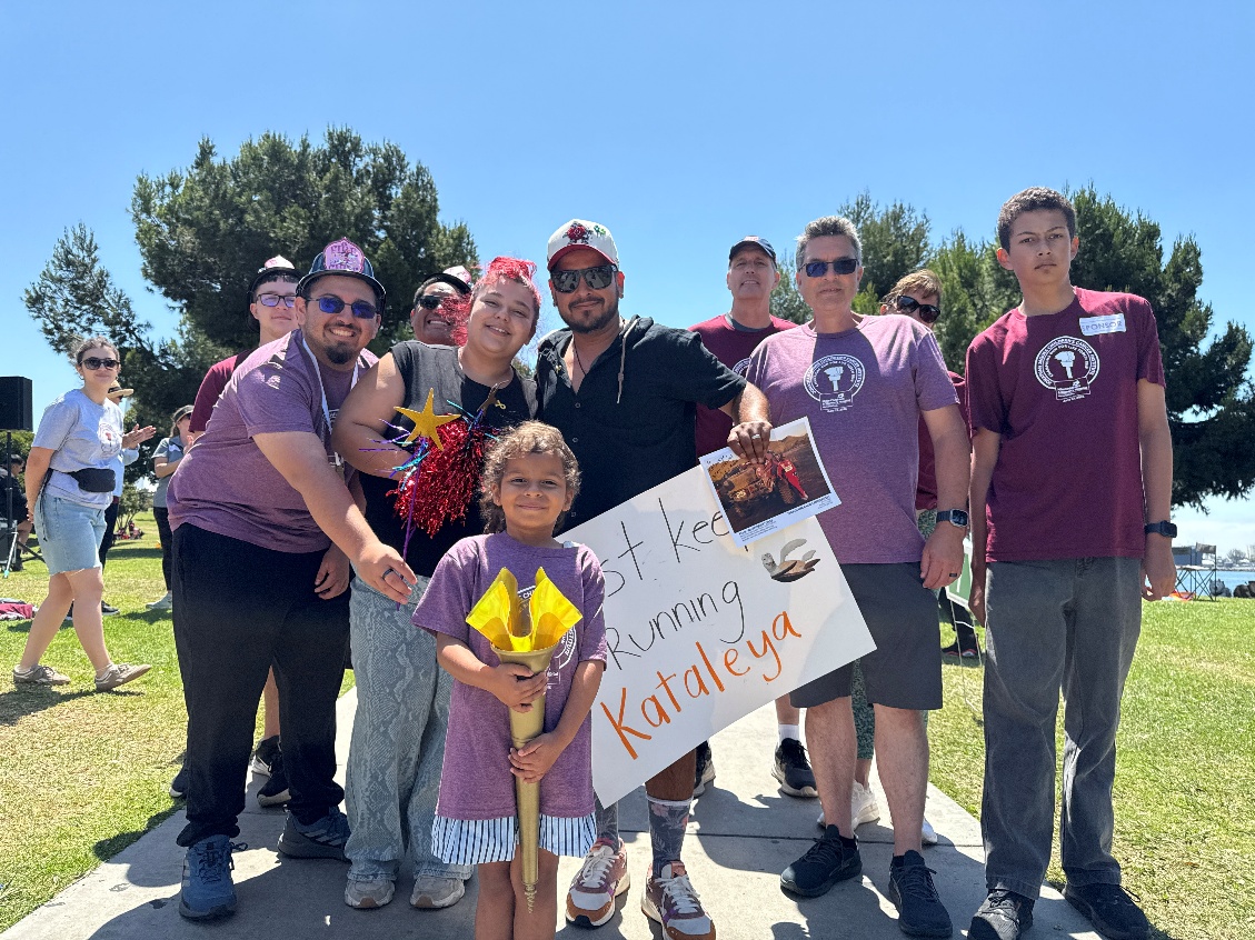The Suazo family runs with 6-year-old Kataleya, who is in...
