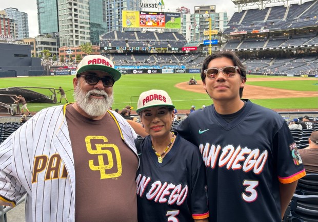 Luis Garcia (right) watched Friday's game from field-level seats with his mom and stepfather, Angela and Robert Azhocar. (Kirk Kenney / San Diego Union-Tribune)