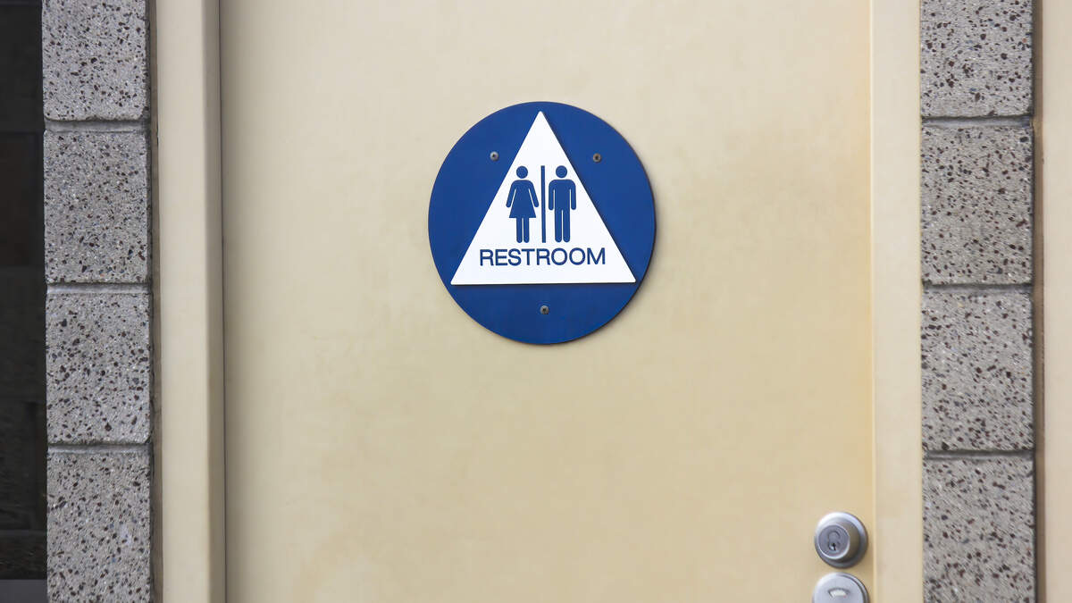 A sign on the door of a public restroom indicates that it is available for all genders. A sign on the door of a public restroom indicates that it is available for all genders.