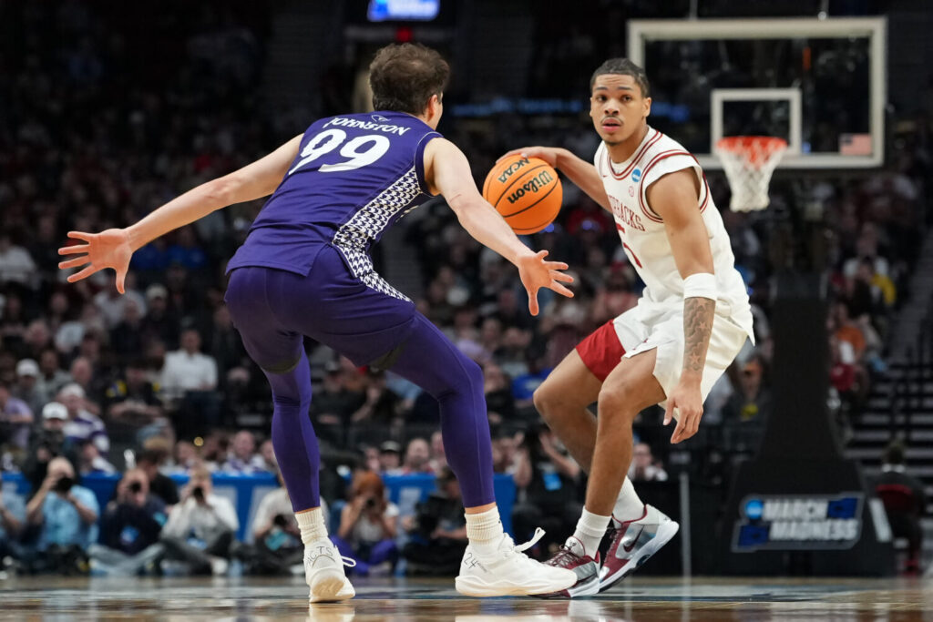 PORTLAND, OREGON - MARCH 21: Darius Acuff Jr. #5 of the Arkansas Razorbacks dribbles the ball while being guarded by Chase Johnston #99 of the High Point Panthers during the second half in the second round of the 2026 NCAA Men's Basketball Tournament at Moda Center on March 21, 2026 in Portland, Oregon. (Photo by Soobum Im/Getty Images)