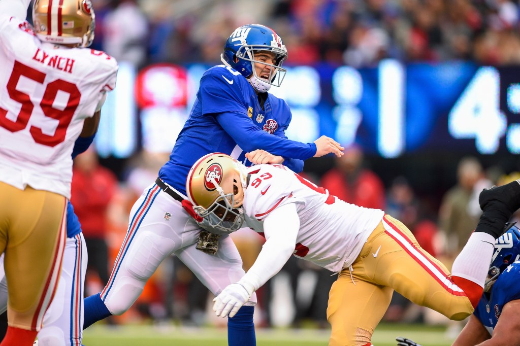New York Giants quarterback Eli Manning (10) is hit by San Francisco 49ers outside linebacker Aldon Smith (99) during the first half of a NFL game between the San Francisco 49ers and the New York Giants at MetLife Stadium in East Rutherford, NJ.