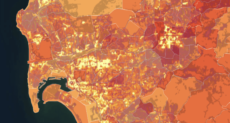 Heat map of a city's population density, showing varying shades of orange and red. Dark red areas indicate higher density, while lighter orange suggests lower density. Coastal region is visible on the left.