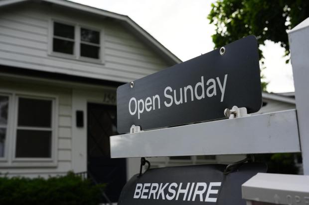Information sign about open house for home sale is seen outside of a home.