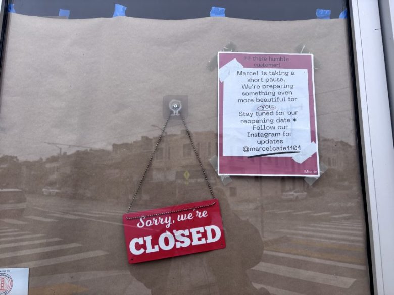 A storefront window displays a "Sorry, we're CLOSED" sign and a printed notice announcing a temporary closure and future reopening updates via Instagram.