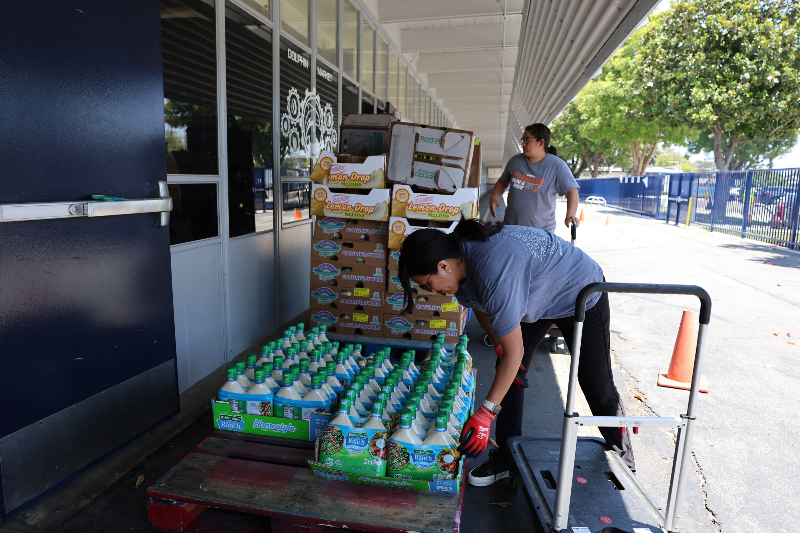 Staff members prepare food and supplies for distribution at the Dolphin Food Market at Pacific Drive Elementary School. The community food pantry operates through a partnership with Second Harvest Food Bank of Orange County.