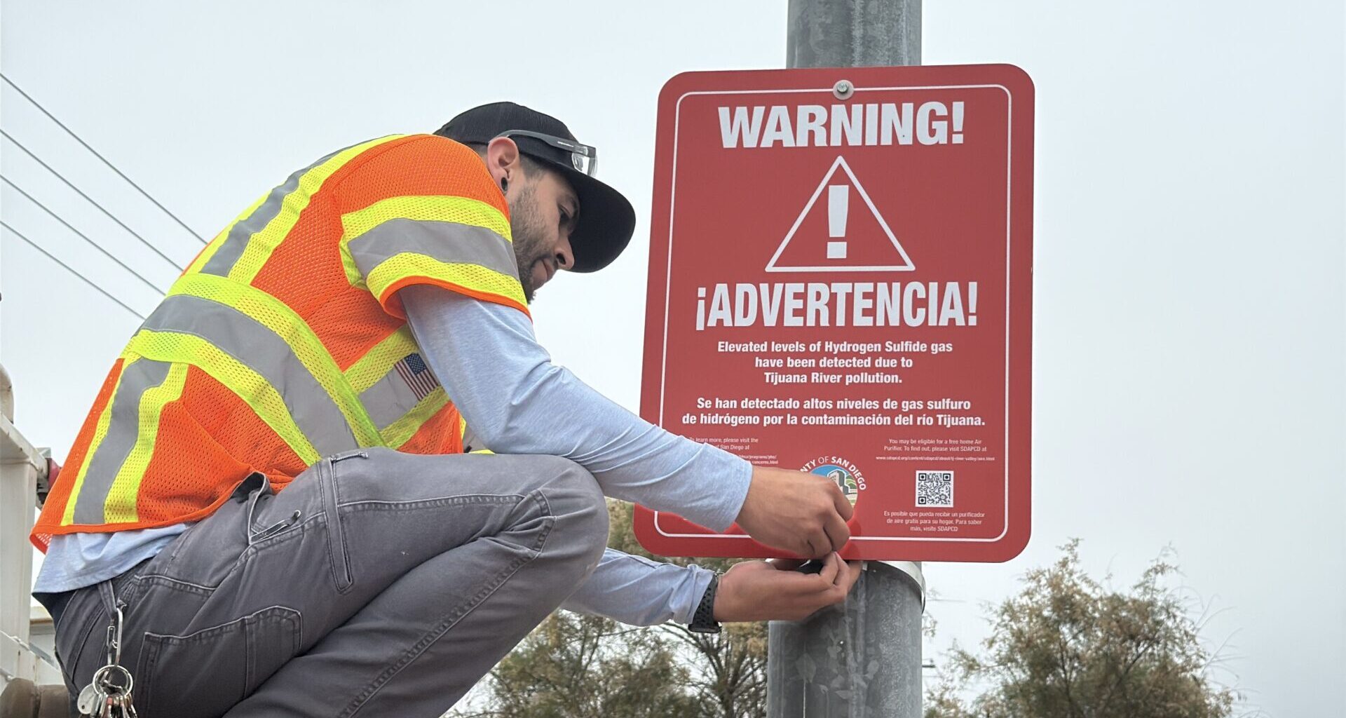worker putting up warning sign