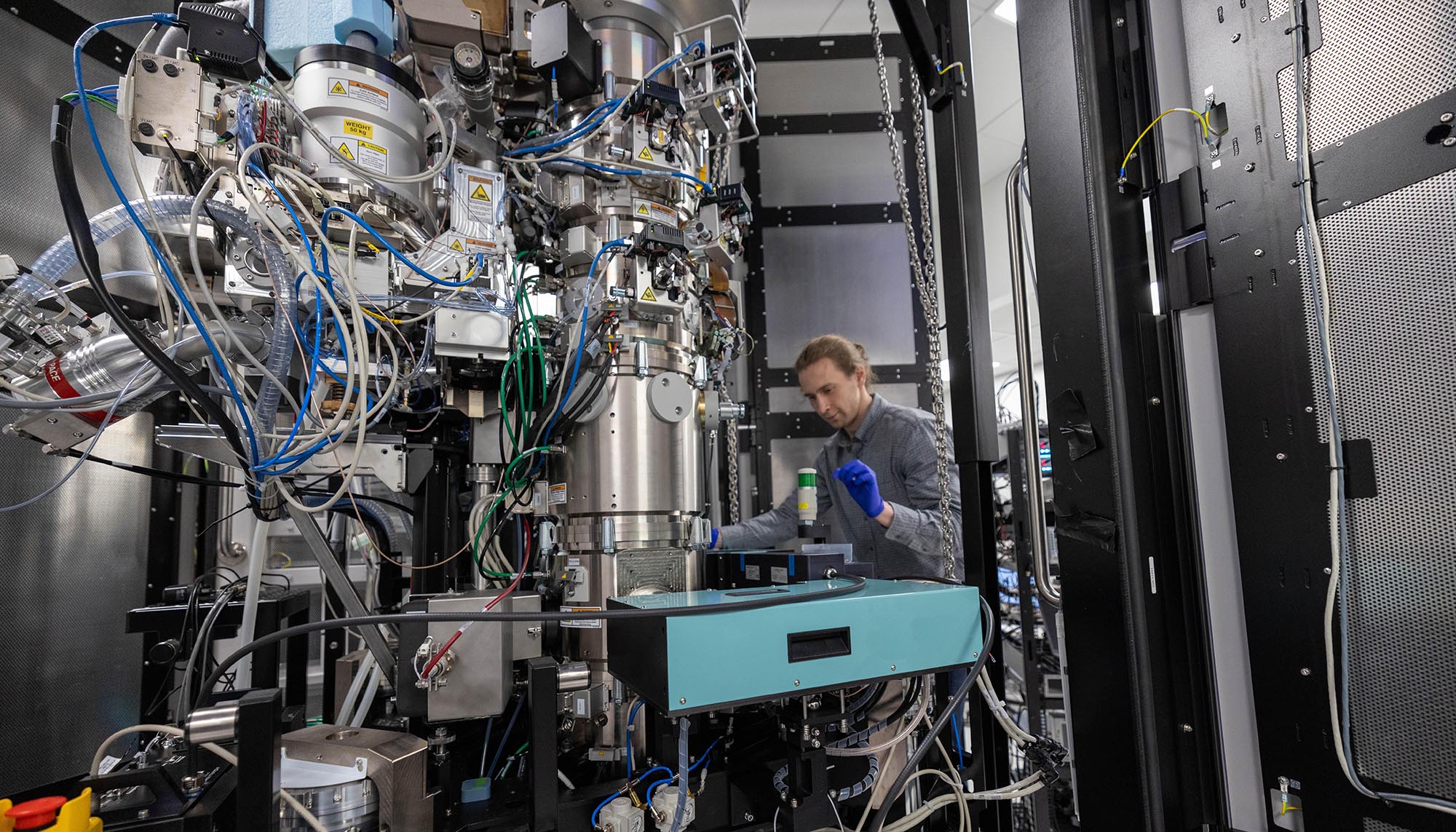 a man working with a large chrome apparatus