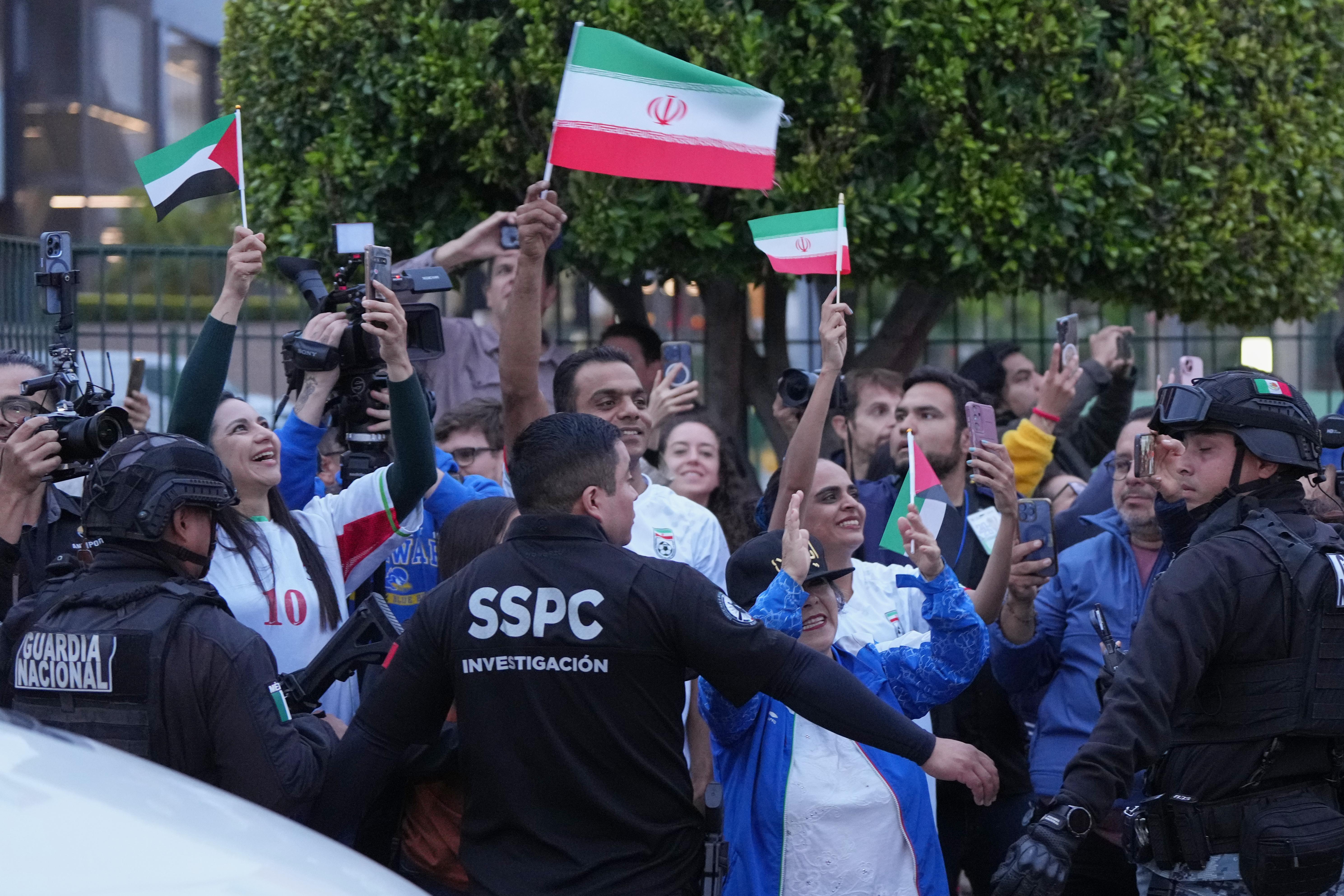 Fans for team Iran wave as players arrive for the World Cup.