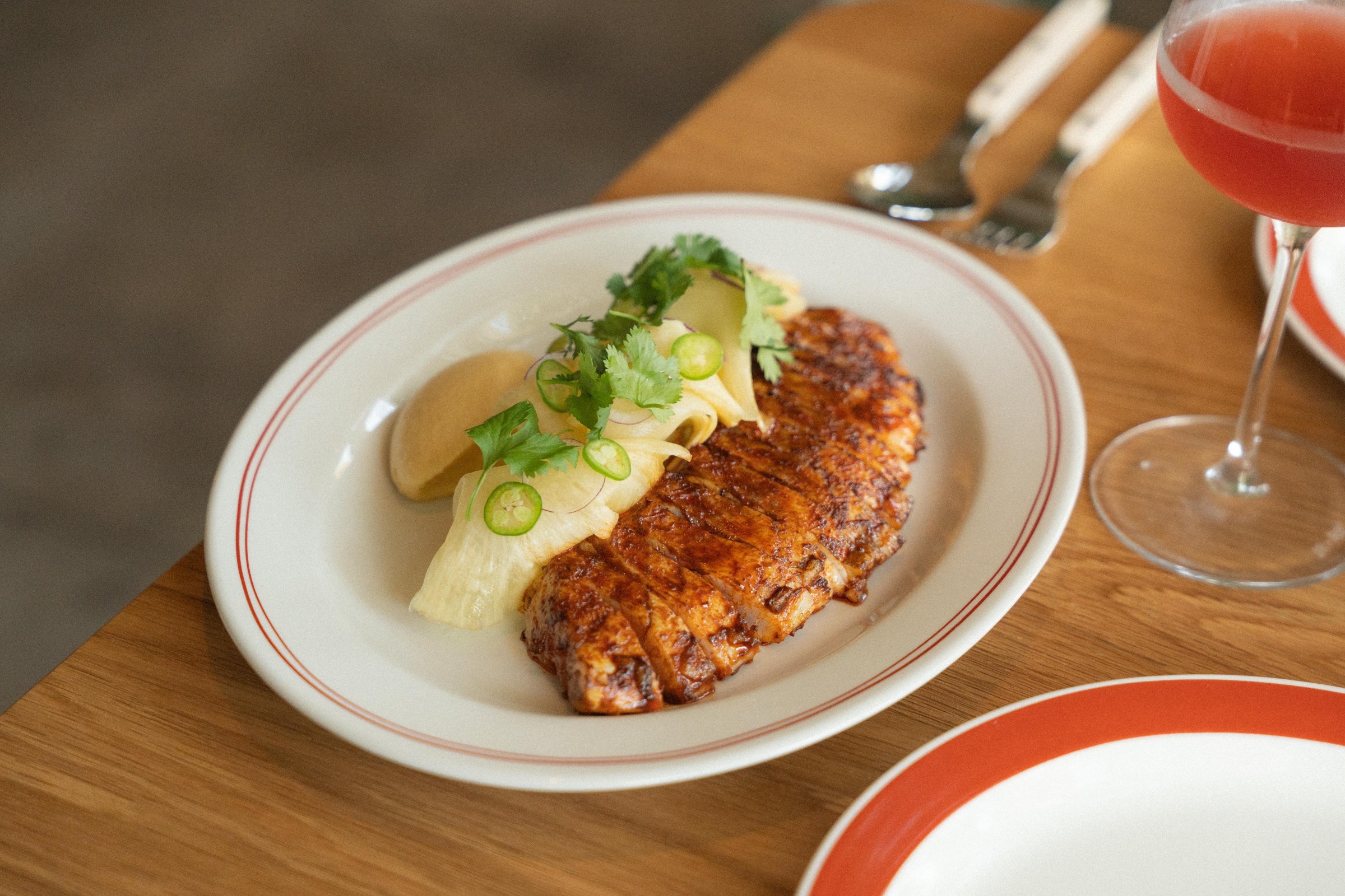 Sliced kanpachi al pastor on a white plate at San Damian.
