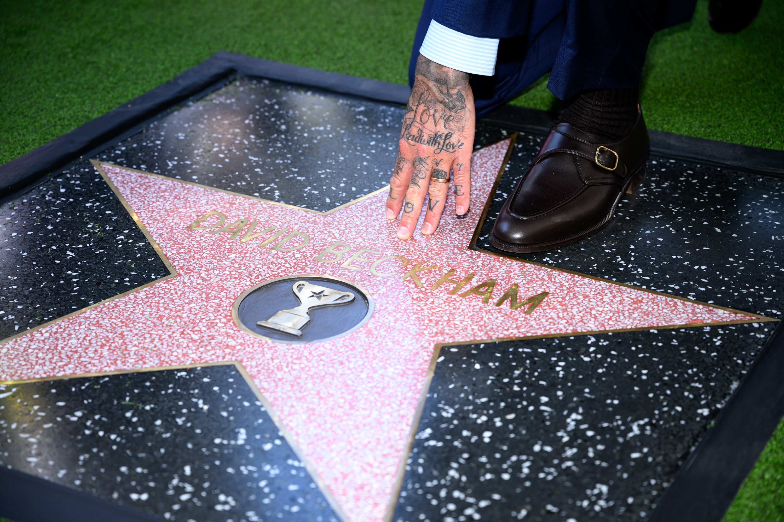 David Beckham poses with his new star on the Hollywood...