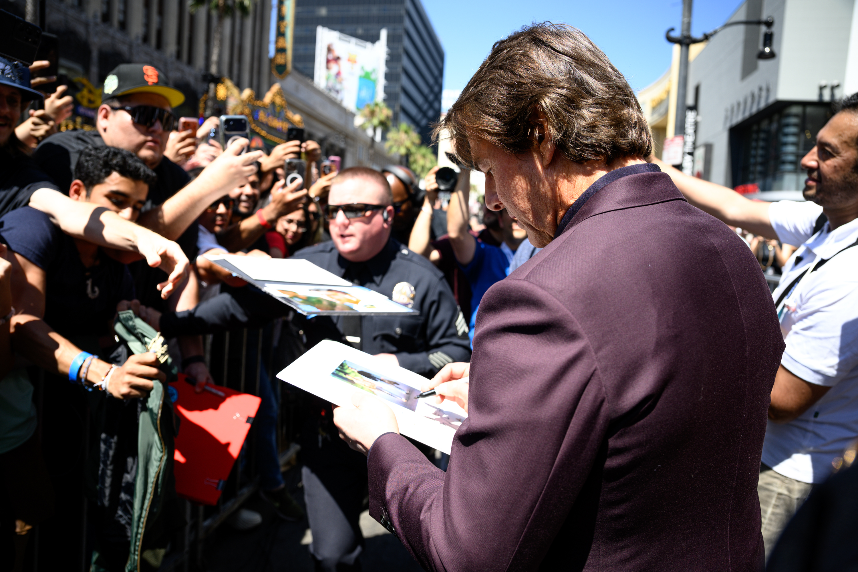 Tom Cruise signs an autograph for a fan after his...
