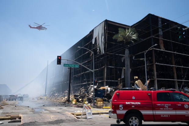 Firefighters continue to douse the Lineage warehouse fire in Boyle Heights with water from the ground and air on Wednesday, June 24, 2026. The LAFD hoped to have the fire 100% contained by midnight. The fire has been burning for seven days. (Photo by David Crane, Los Angeles Daily News/SCNG)