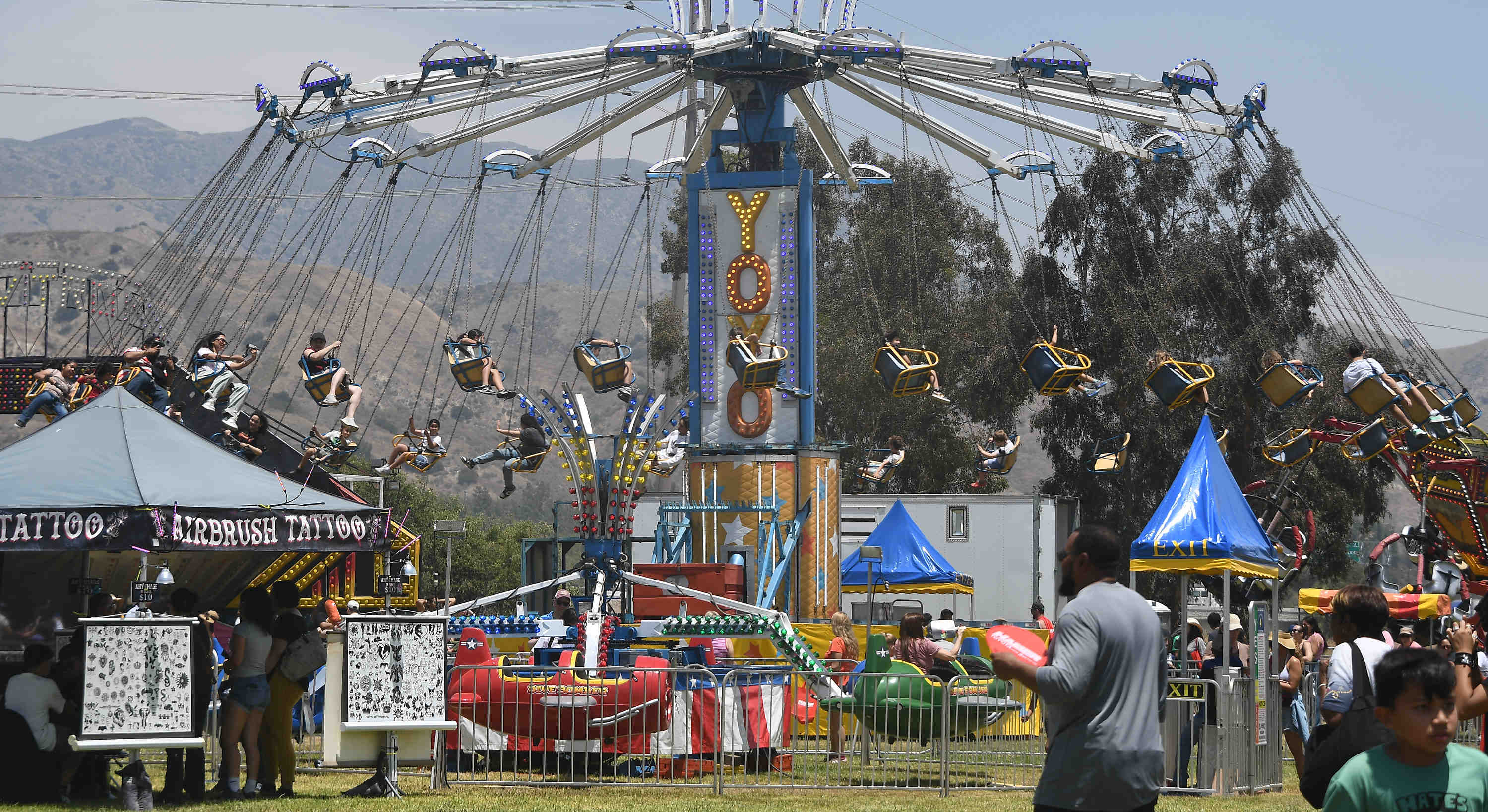 Kids and parent enjoy the carnival rides during the California...
