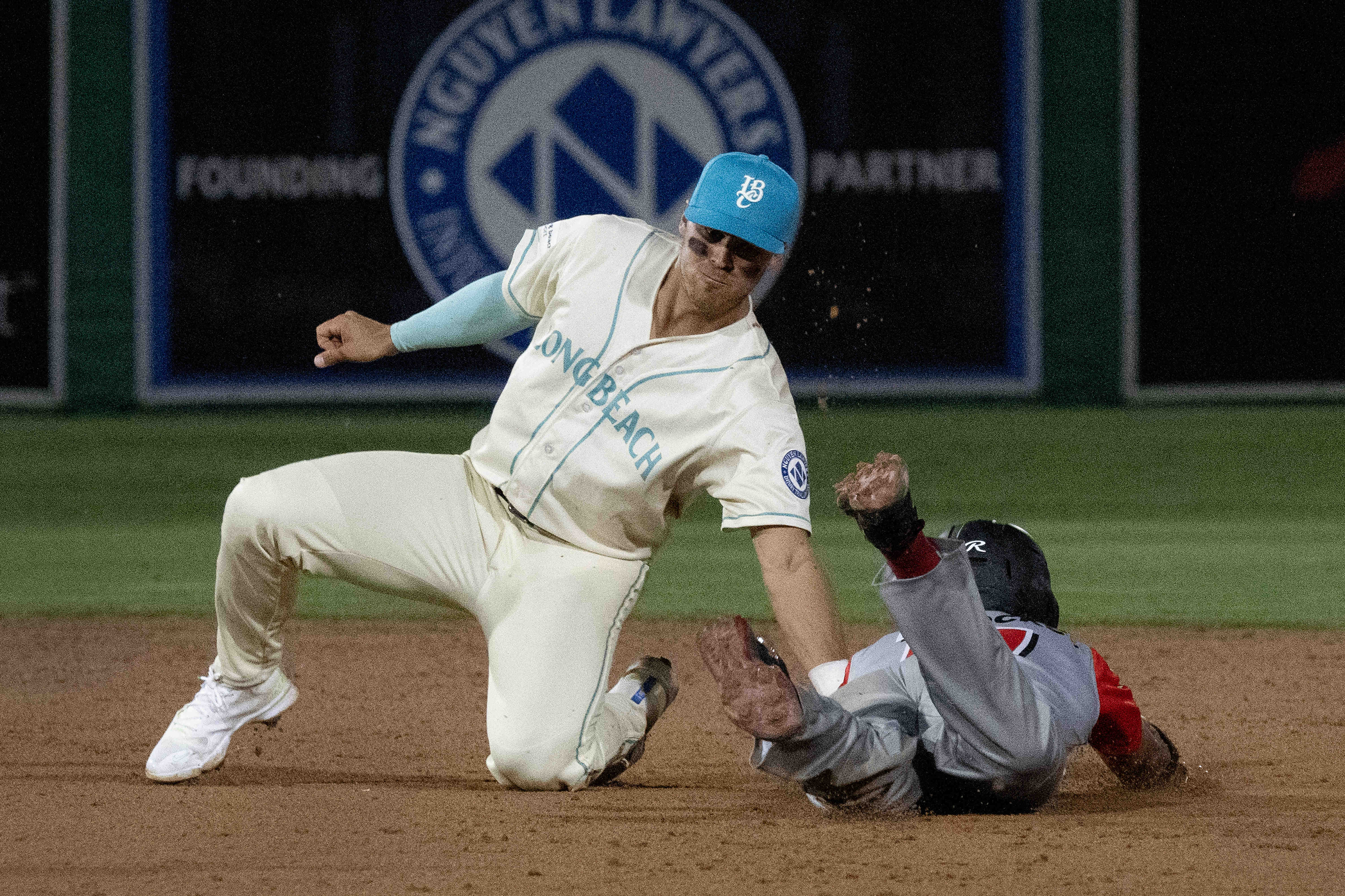 From left, Long Beach Coastâs Jacob Jablonski tags out RedPocket...