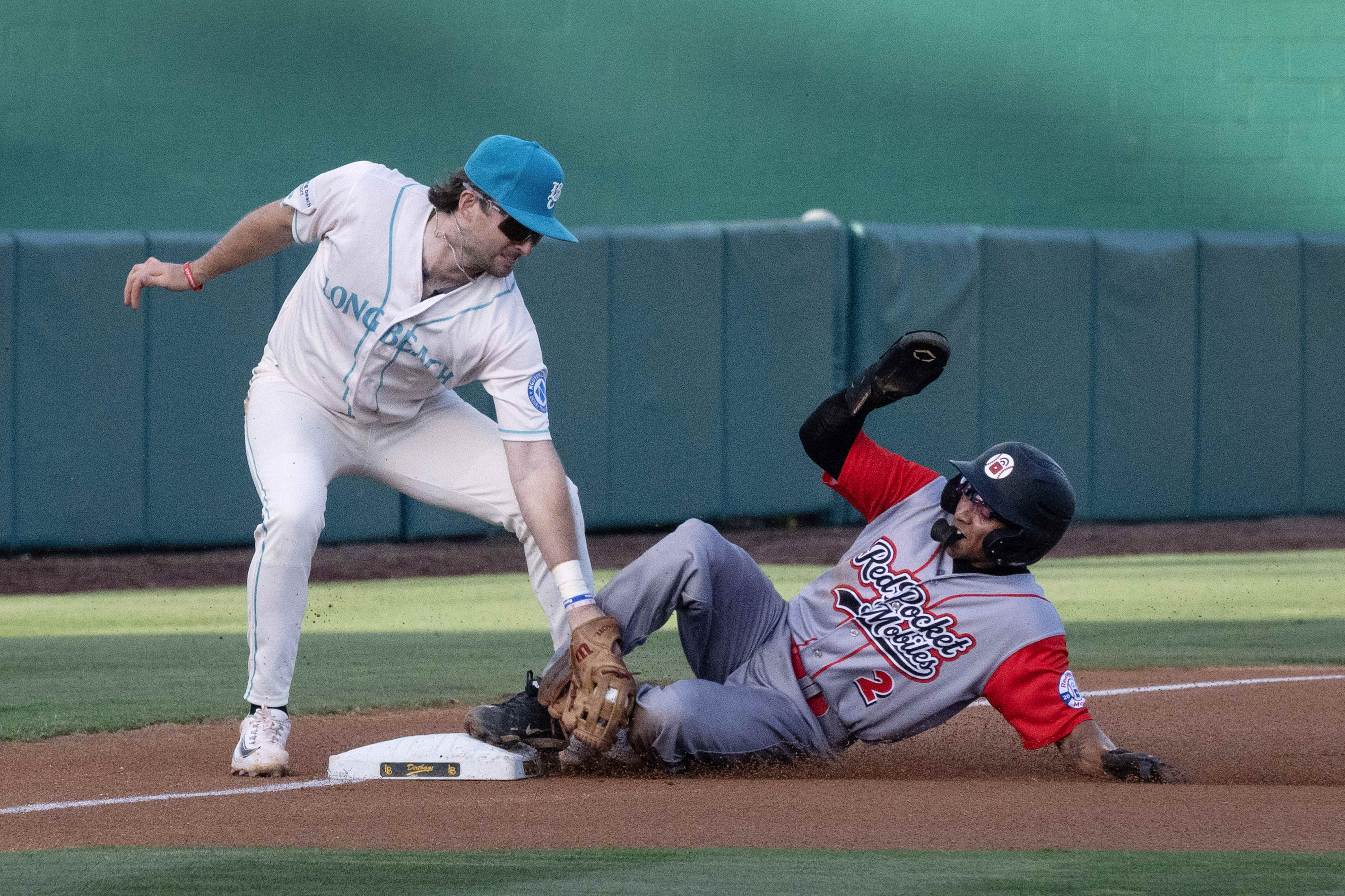 From left, Long Beach Coastâs Patrick Roche tags out RedPocket...