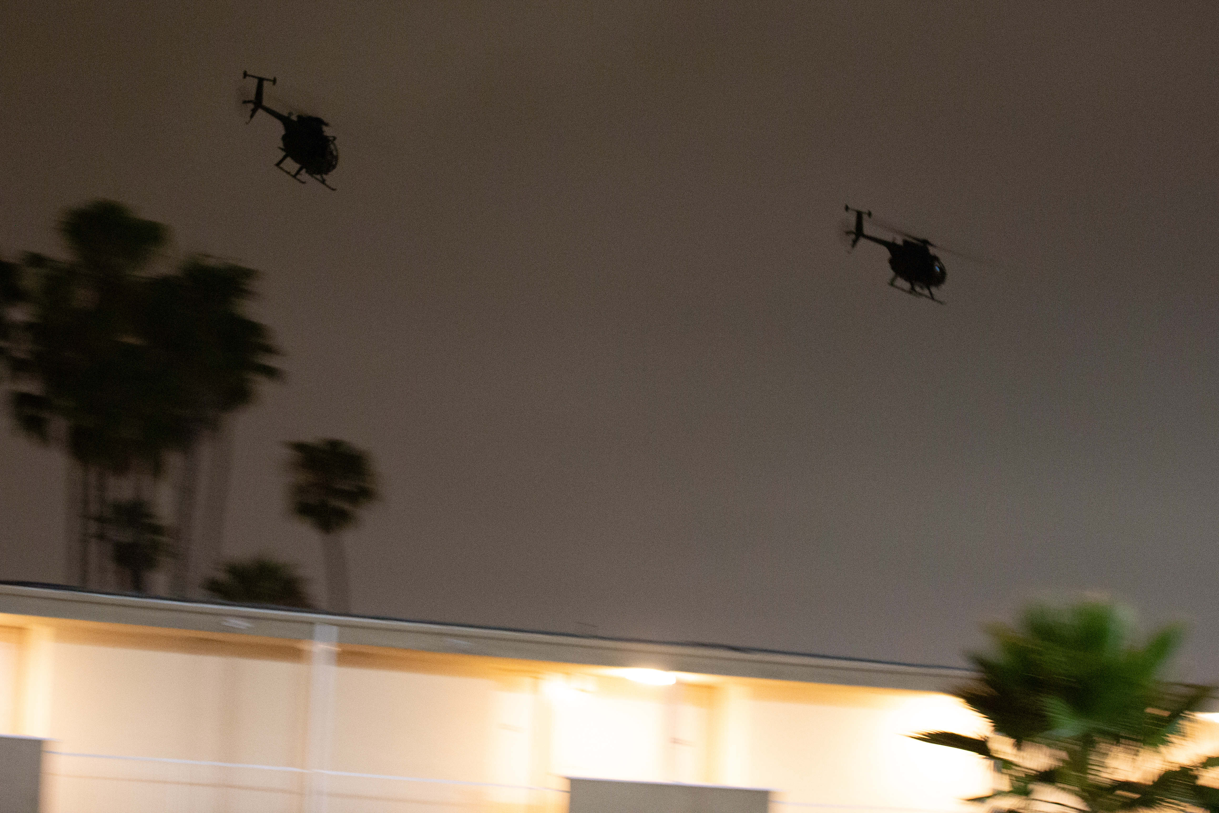 A pair of MH-6 Little Bird helicopters fly off after...