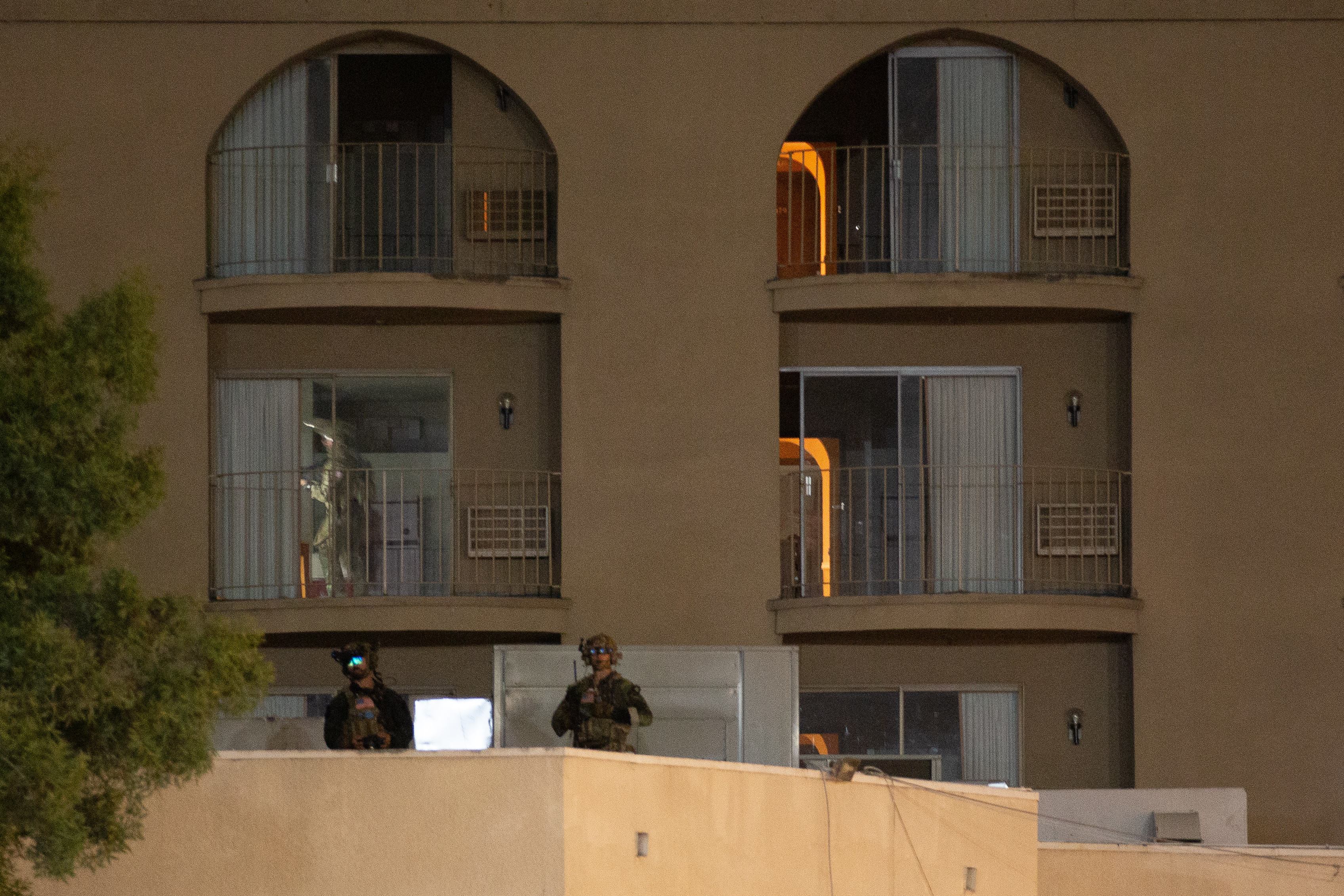 With guns drawn, a soldier clears through a second floor...
