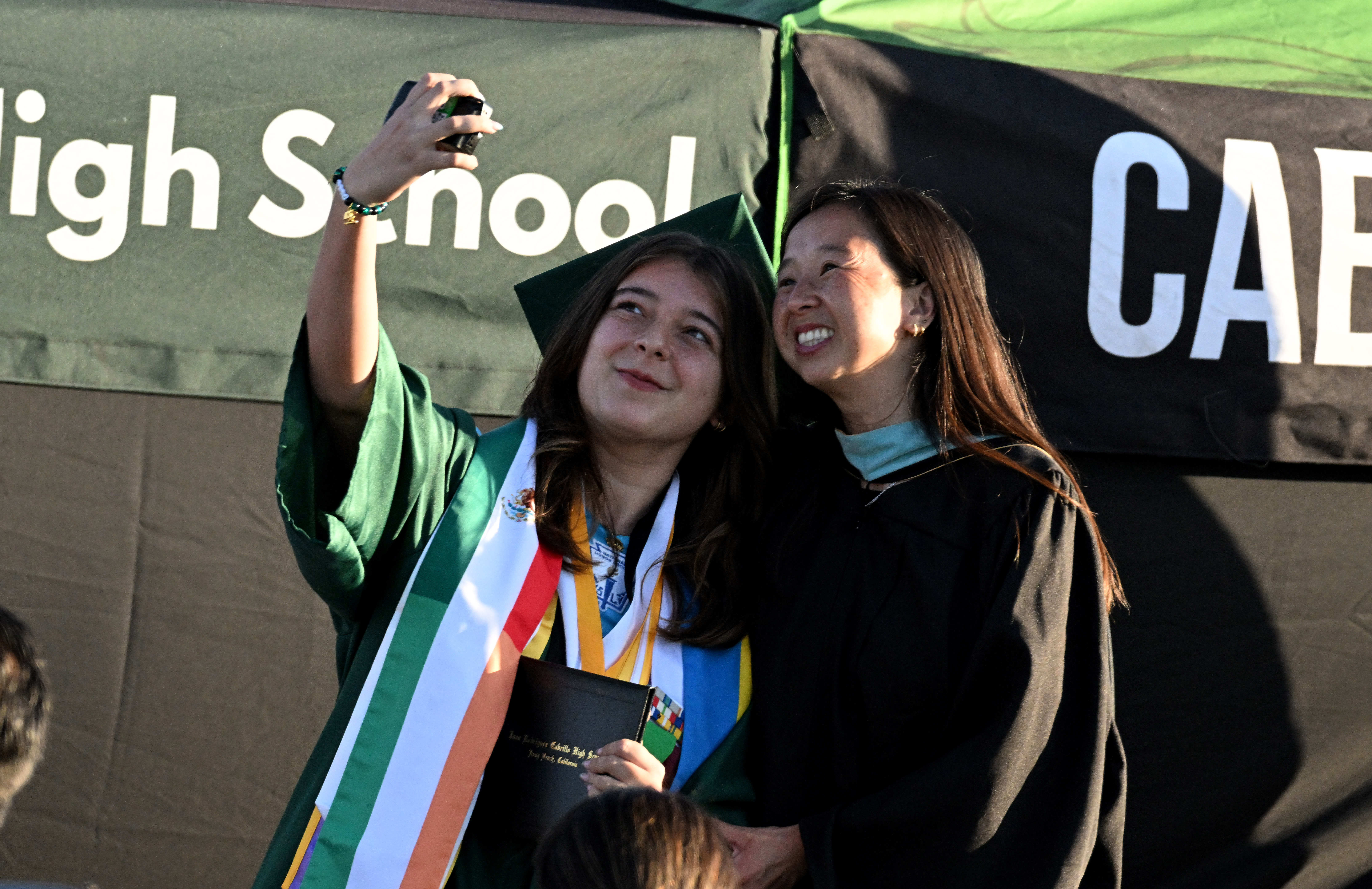Senior Anika Wholey, left, takes a selfie with Principal Ngoc...