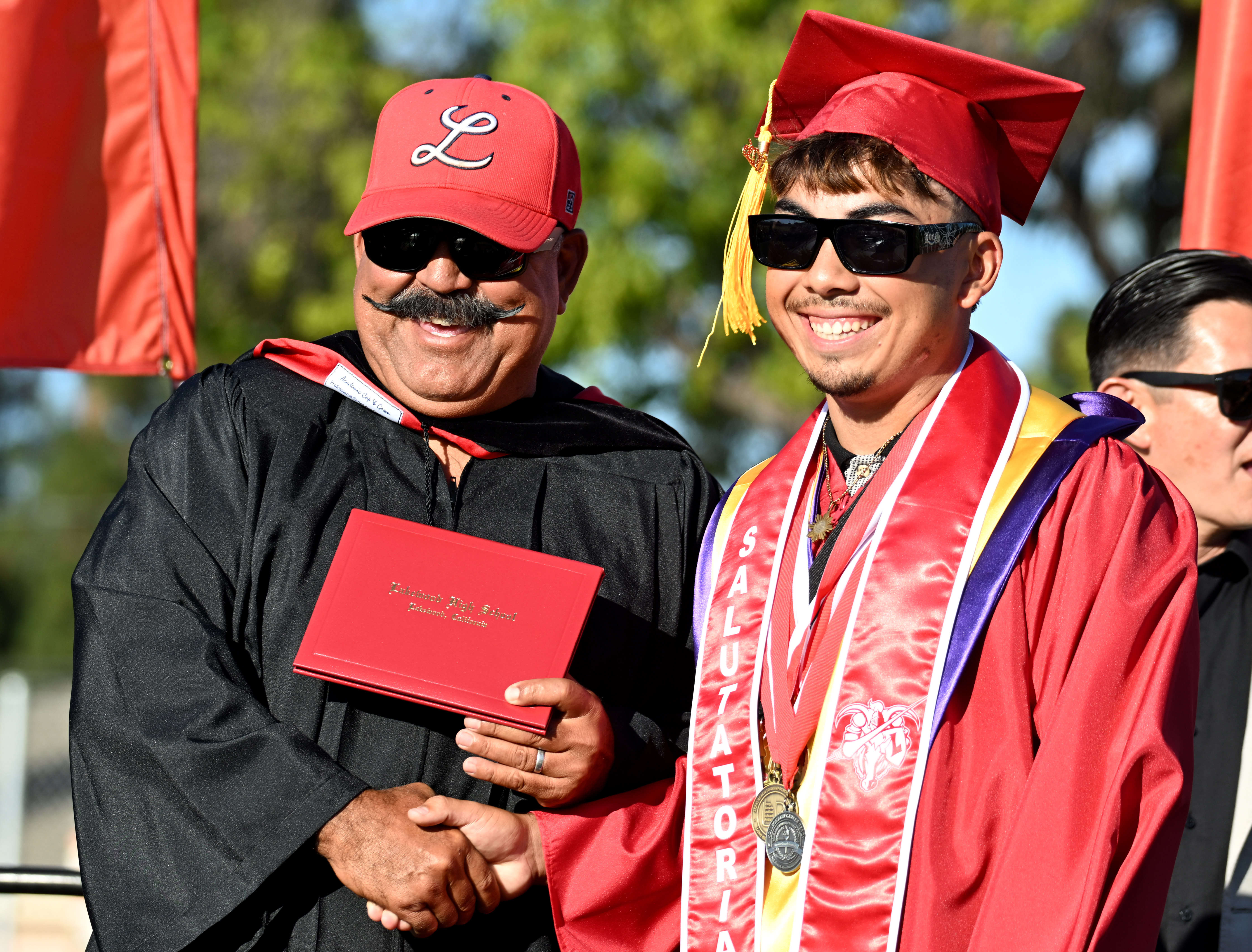 Coach Andy Miramontes awards his son Tanner Miramontes his diploma...