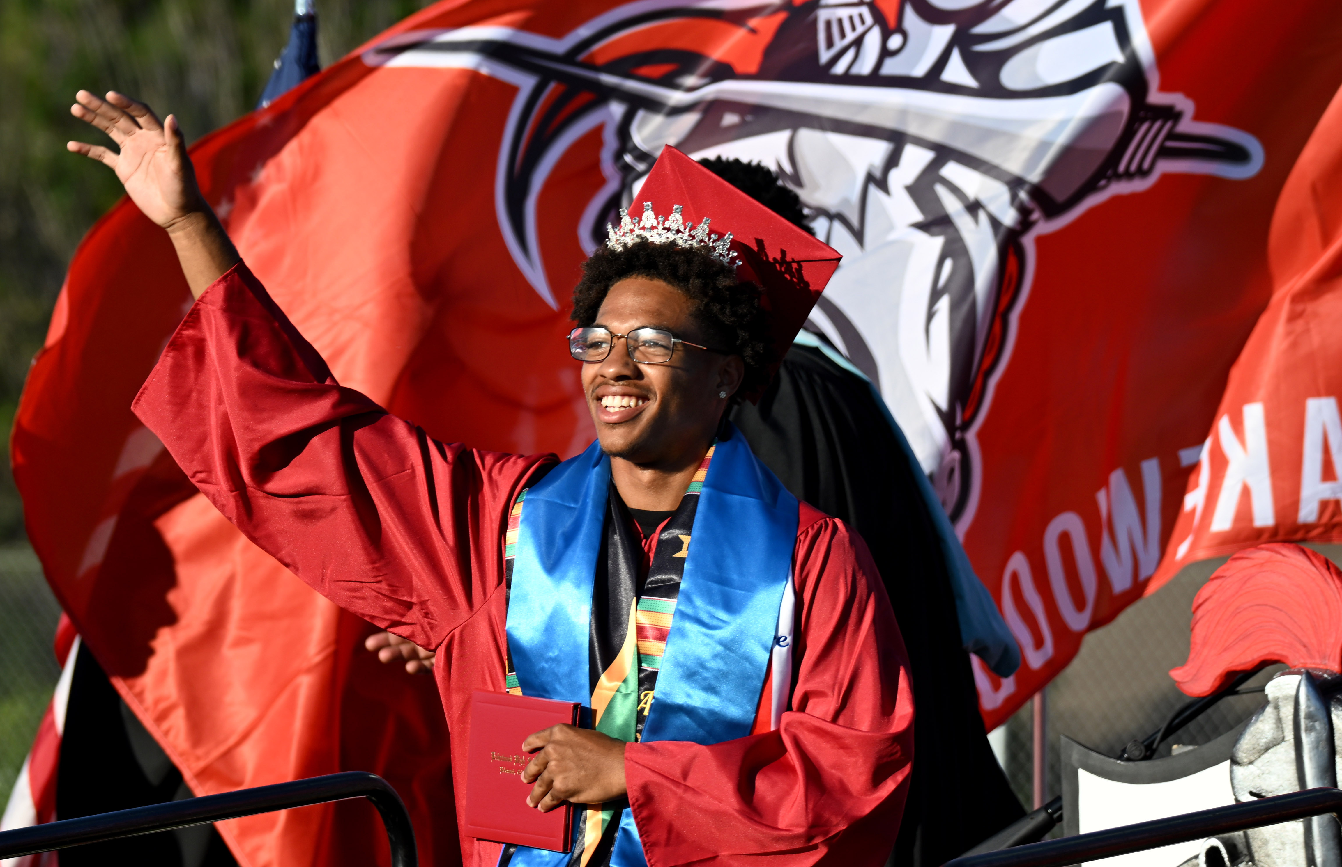 A senior waves to his family after receiving his diploma...