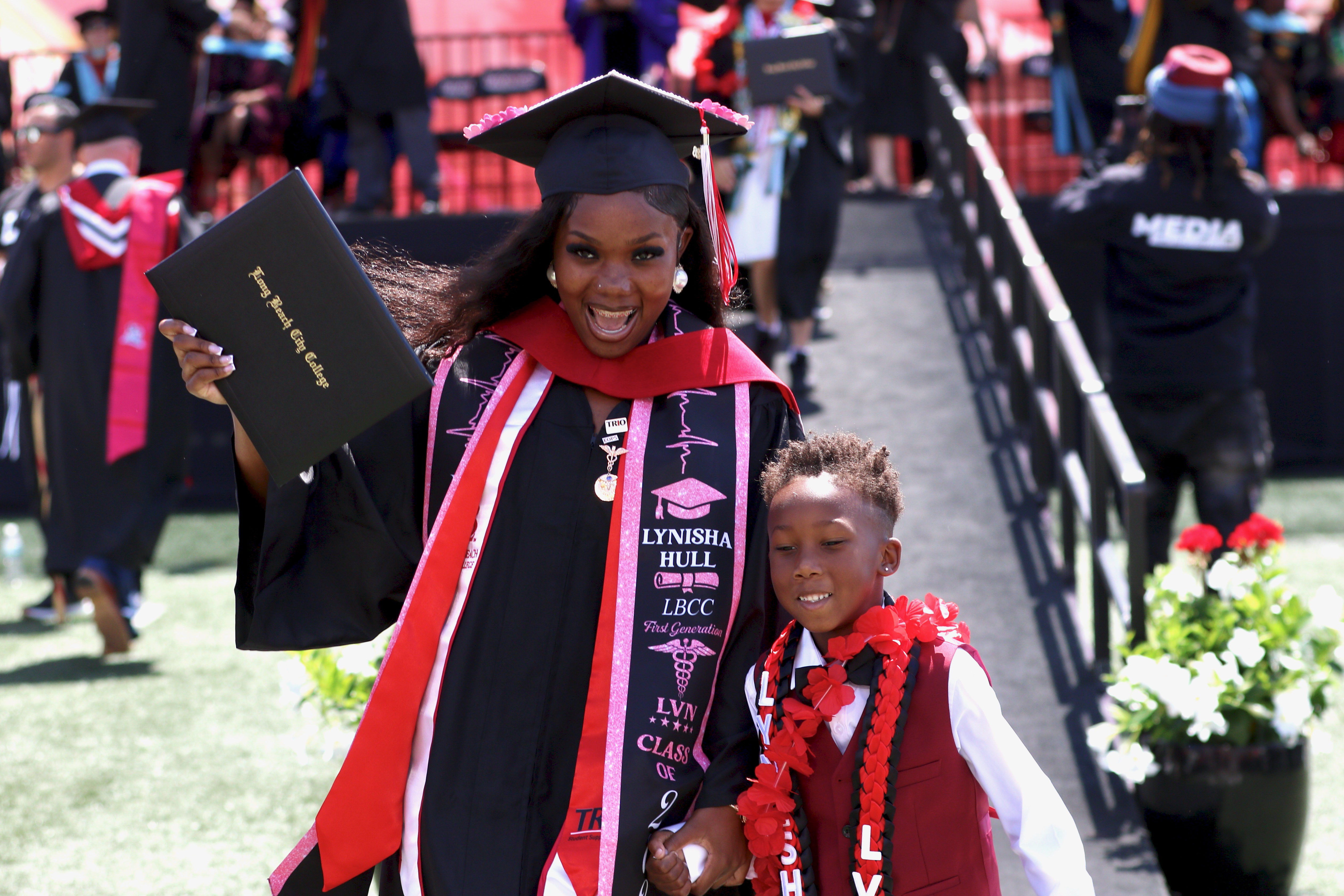 Graduates walks off the stage with diplomas in hand at...