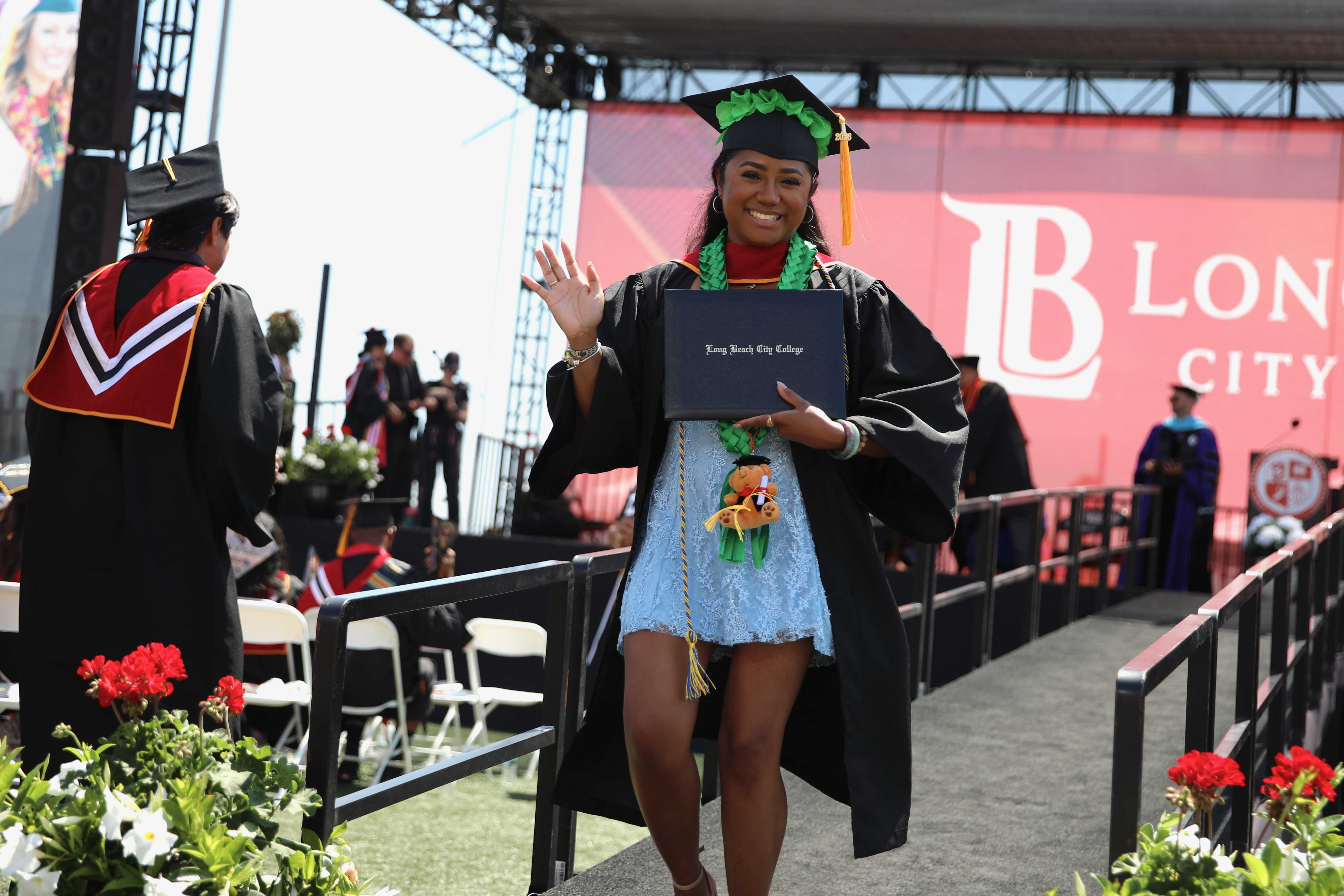 Graduates walks off the stage with diplomas in hand at...