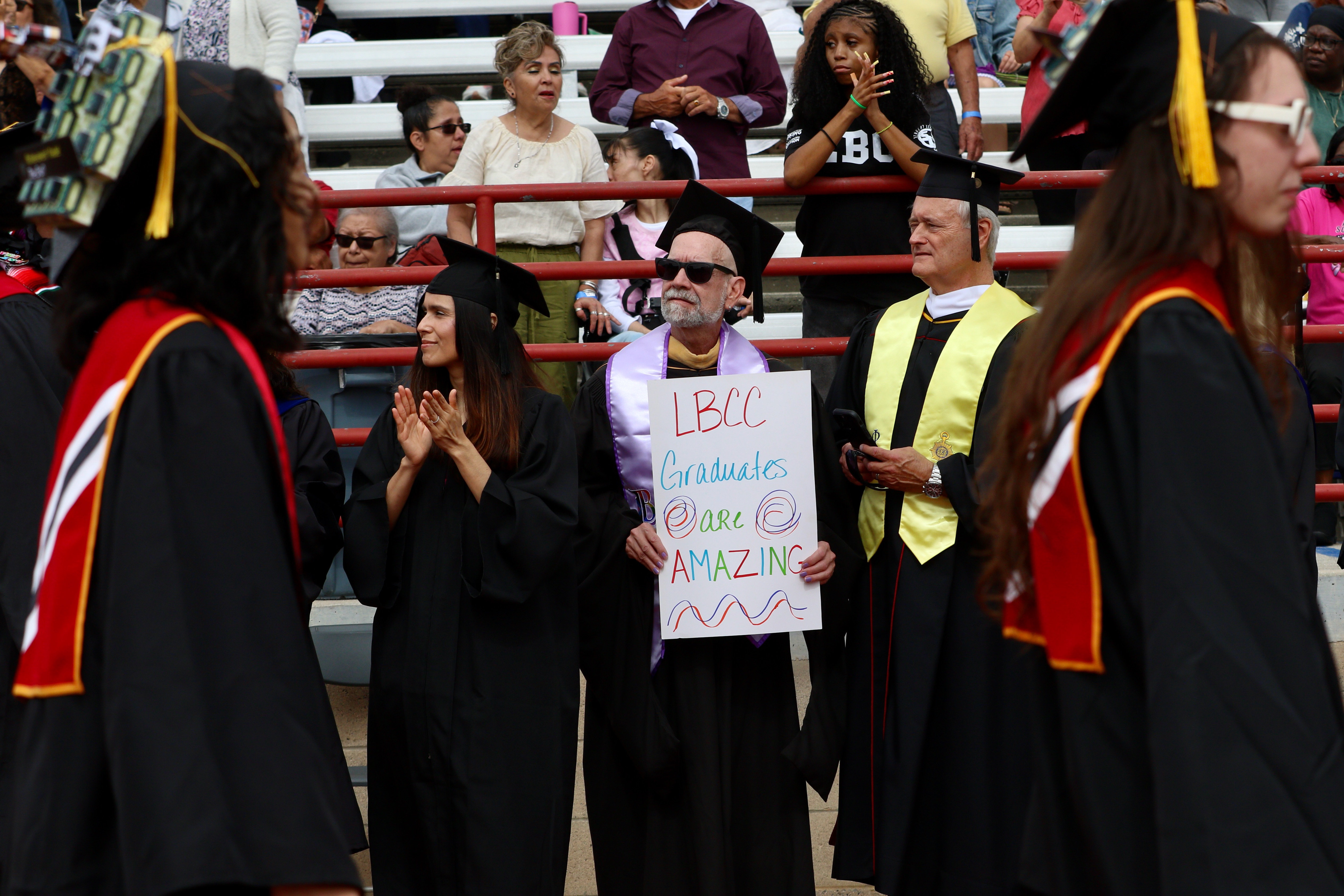 Graduating students are greeted by proud faculty members at Long...