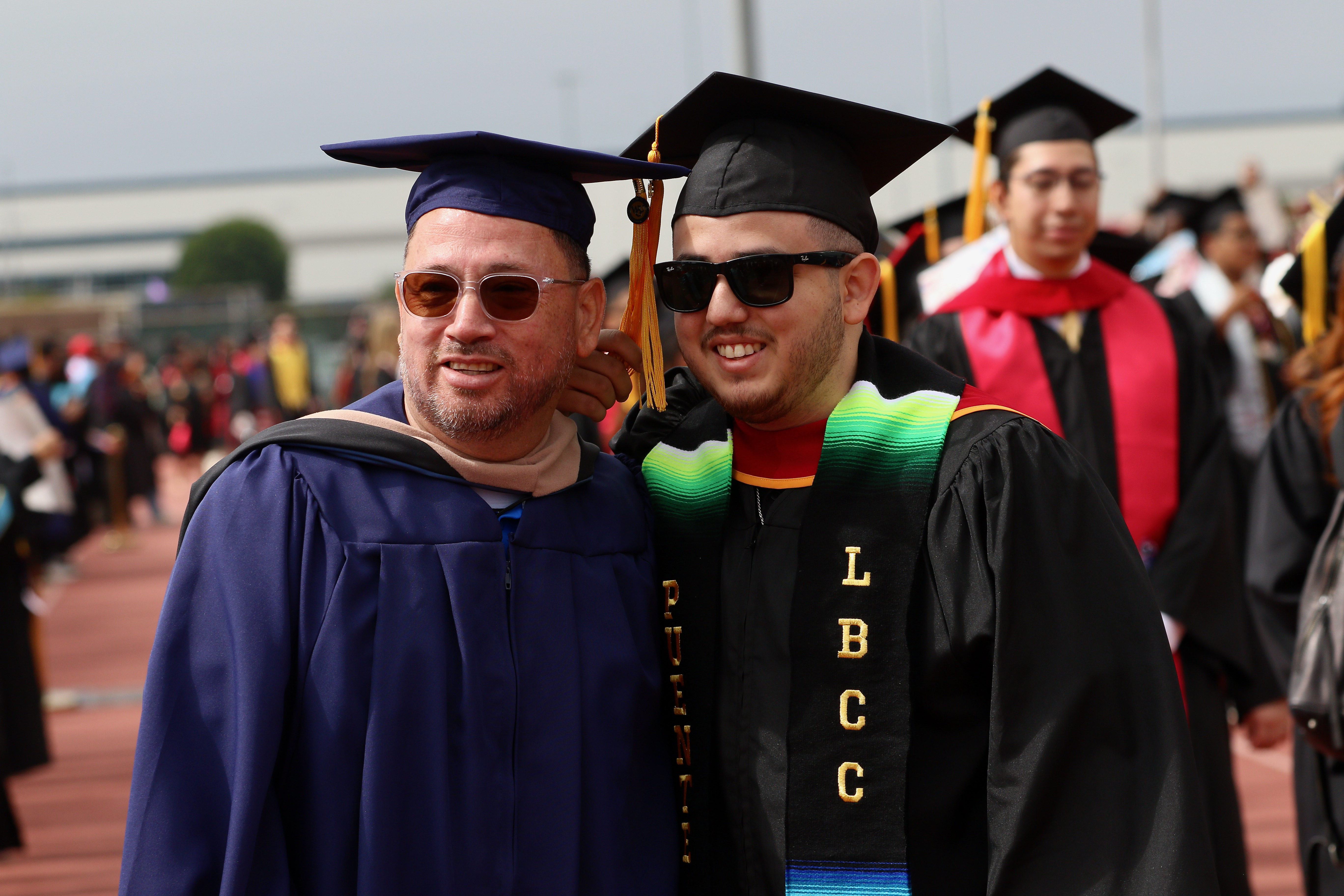 Graduating senior Sebastian Menjivar, right, is greeted by his father...