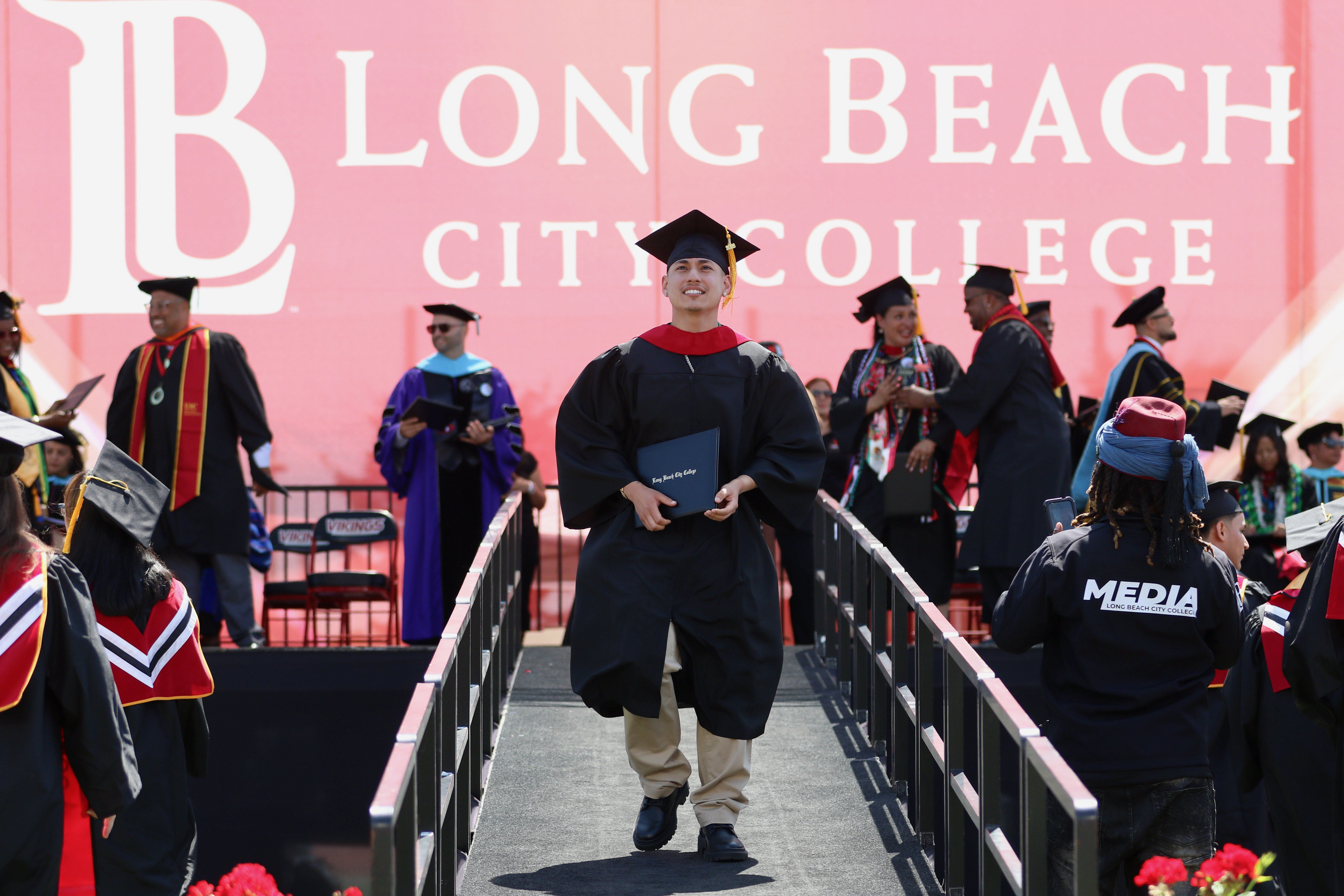 Graduates walks off the stage with diplomas in hand at...