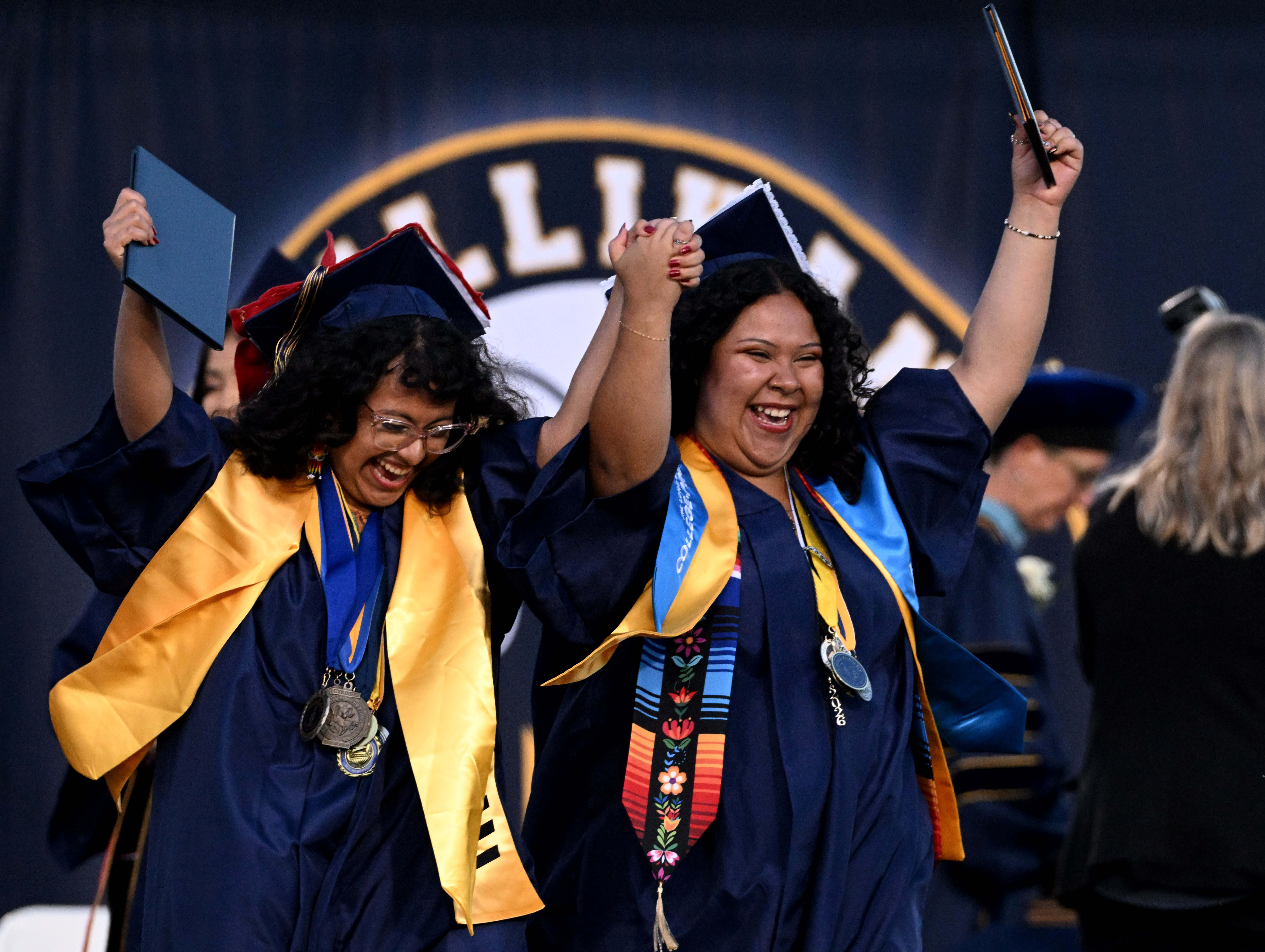 Seniors celebrate as they exit the stage after receiving their...