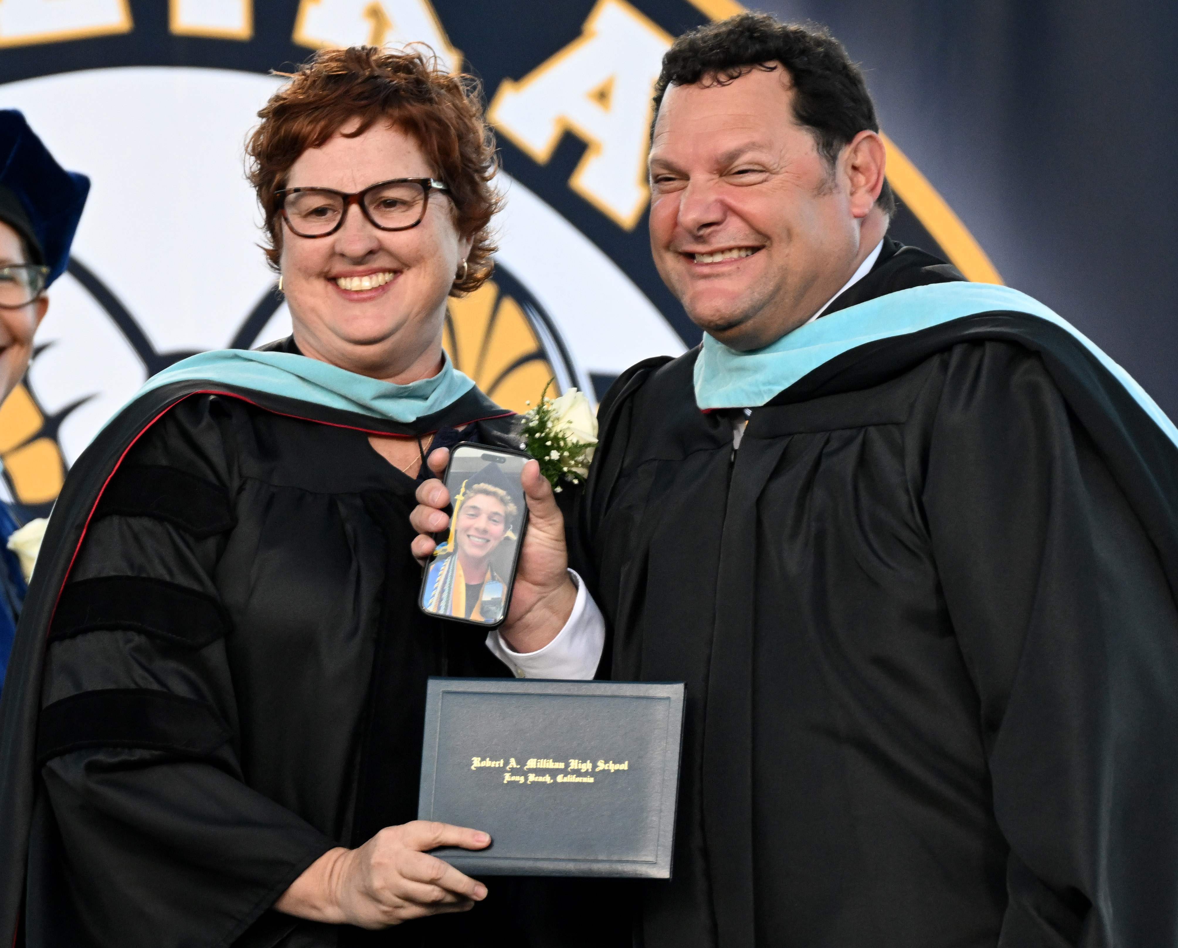 Principal Dr. Stacie Alexander, left, delivers a diploma to a...