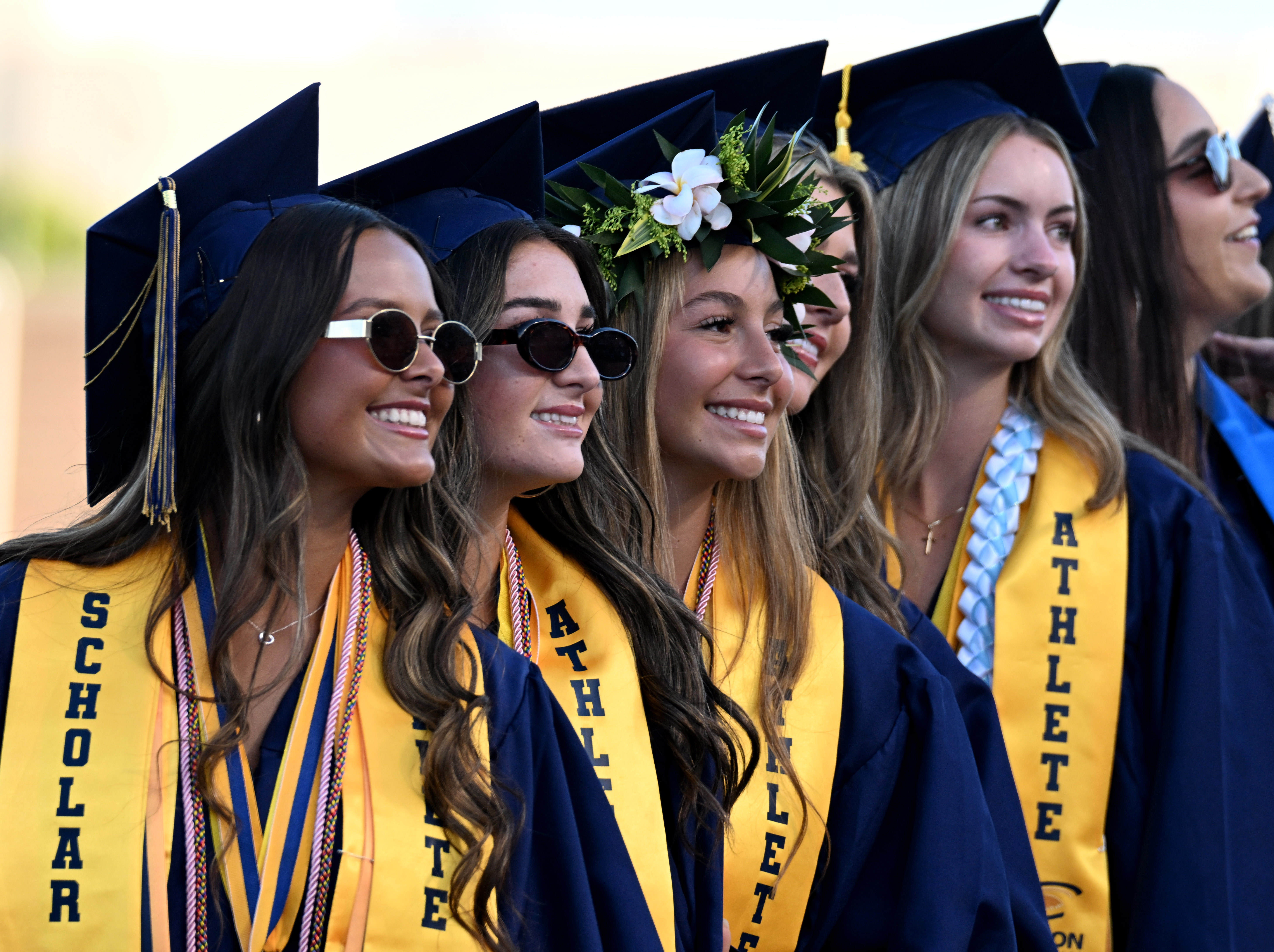 Seniors smile at their families in the crowd as they...