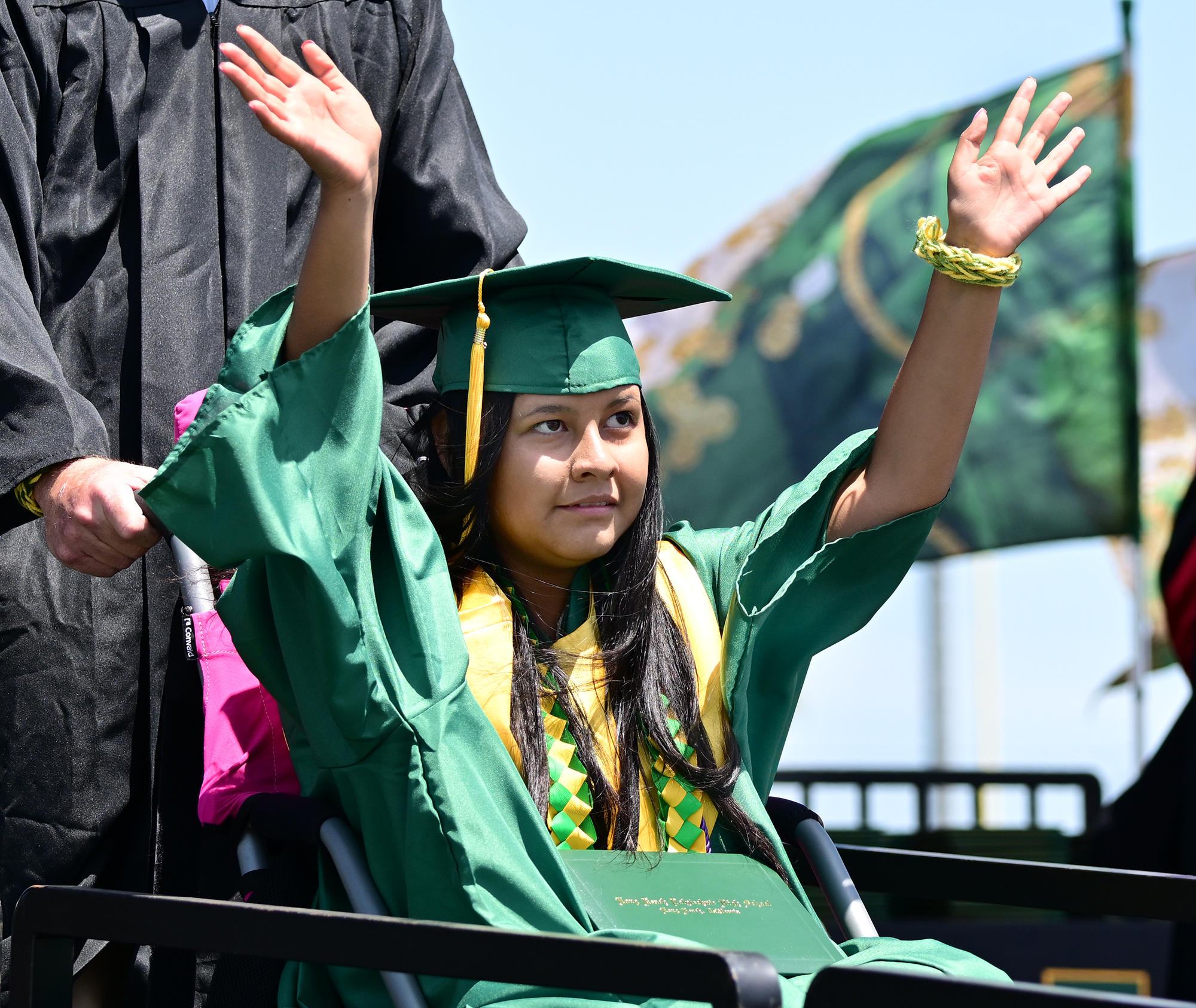 Abigail Martinez waves after receiving her diploma at the Poly...