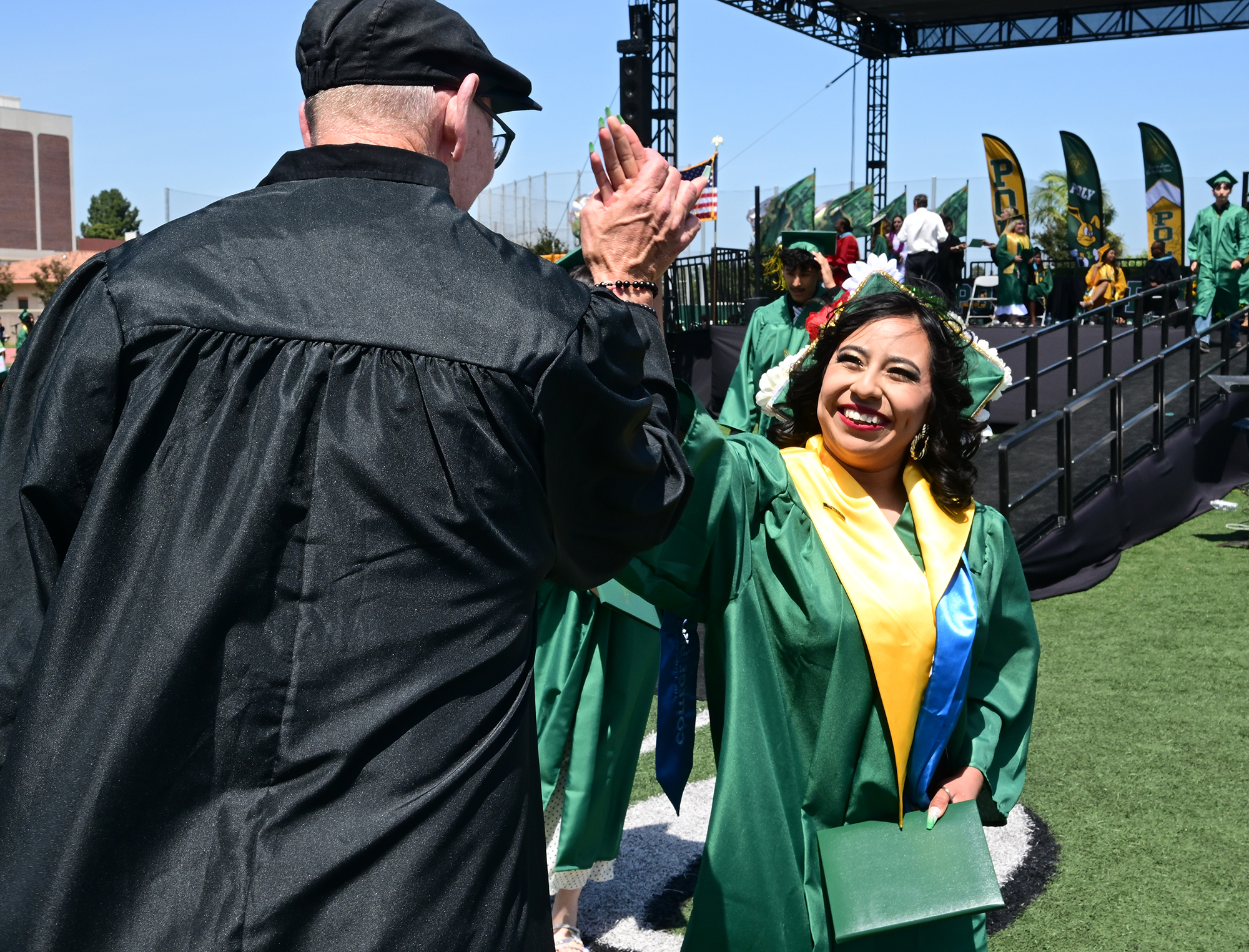 Teacher Michael Gray congratulates Marbella Panzo-Itehua during the Poly High...